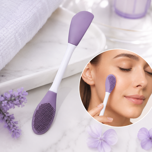 A purple and white double-headed silicone mask brush on a white marble surface with a towel and lavender flowers. Inset: a