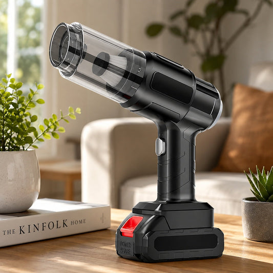 Black handheld vacuum cleaner with a clear dustbin and red battery pack, sitting on a wooden table next to a potted plant.