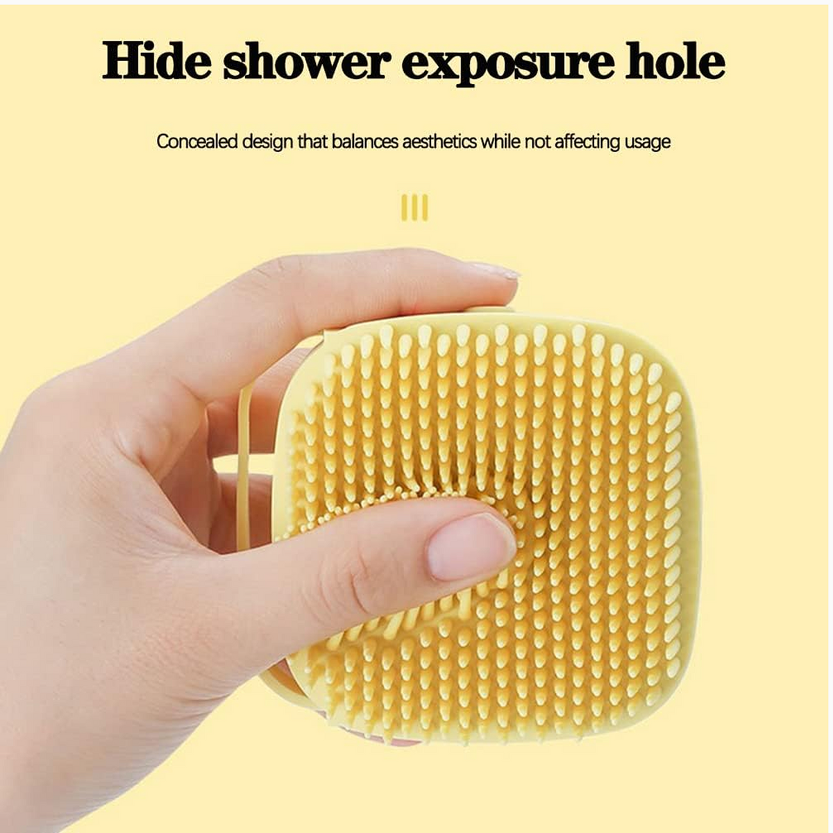 A hand holds the yellow silicone bath brush, showing its soft bristles and a concealed shower exposure hole.