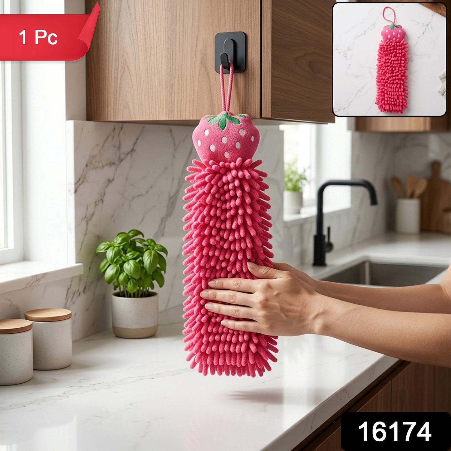 A pink microfiber hand towel with a strawberry top hangs from a hook in a kitchen, with an inset showing a close-up.