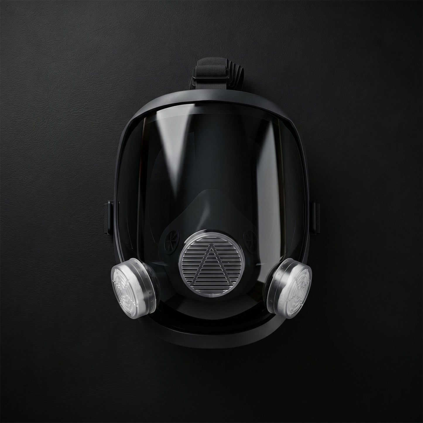 Black full face respirator mask with clear visor and two white filters, centered on a dark background.