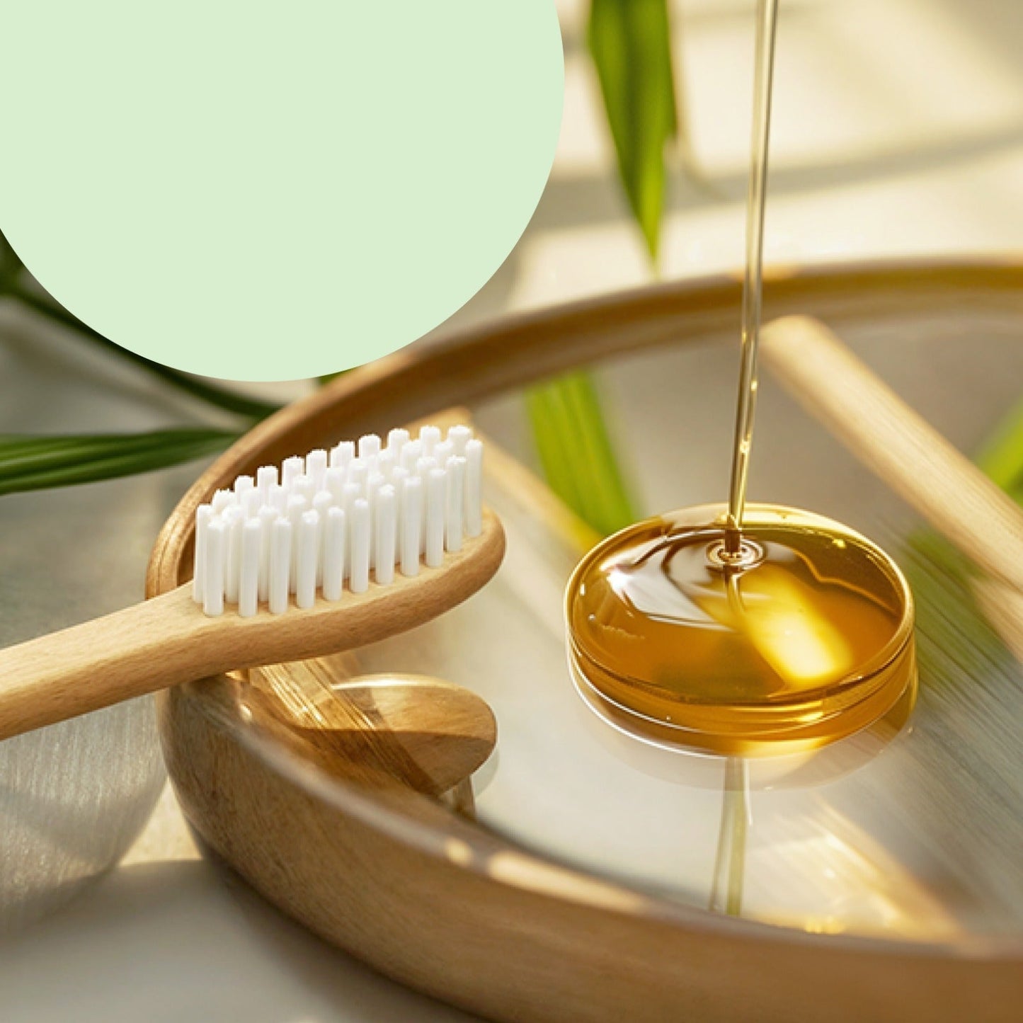 Close-up of a bamboo toothbrush with white bristles next to a wooden tray with a clear liquid being poured into a small dish.