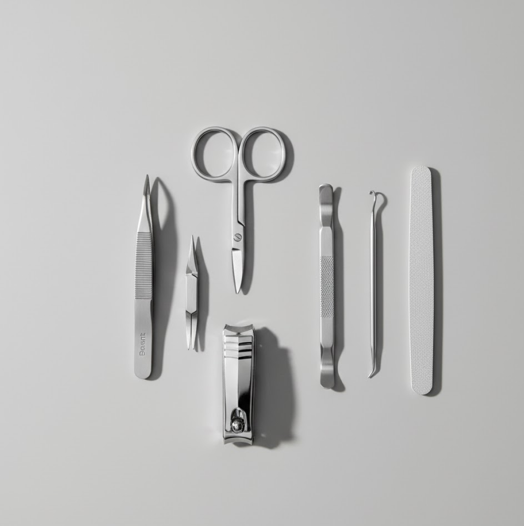 Seven silver manicure tools including clippers, scissors, and files are neatly arranged on a light grey background.
