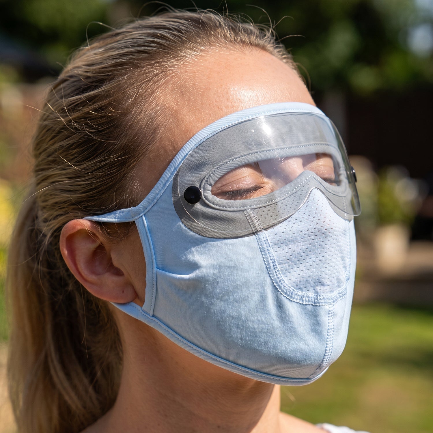 Reusable cloth face mask with eye shield worn outdoors