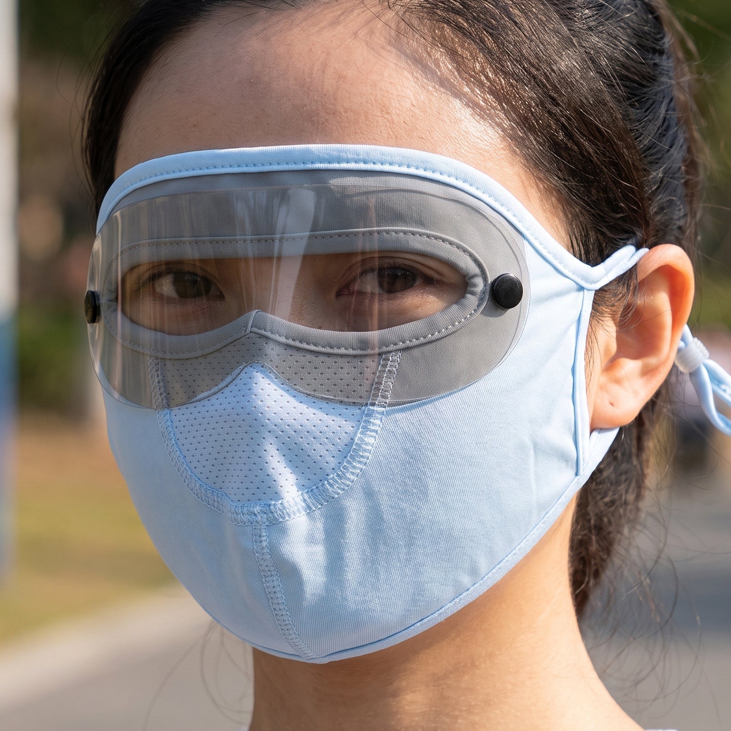 Reusable cloth face mask with transparent eye shield in use