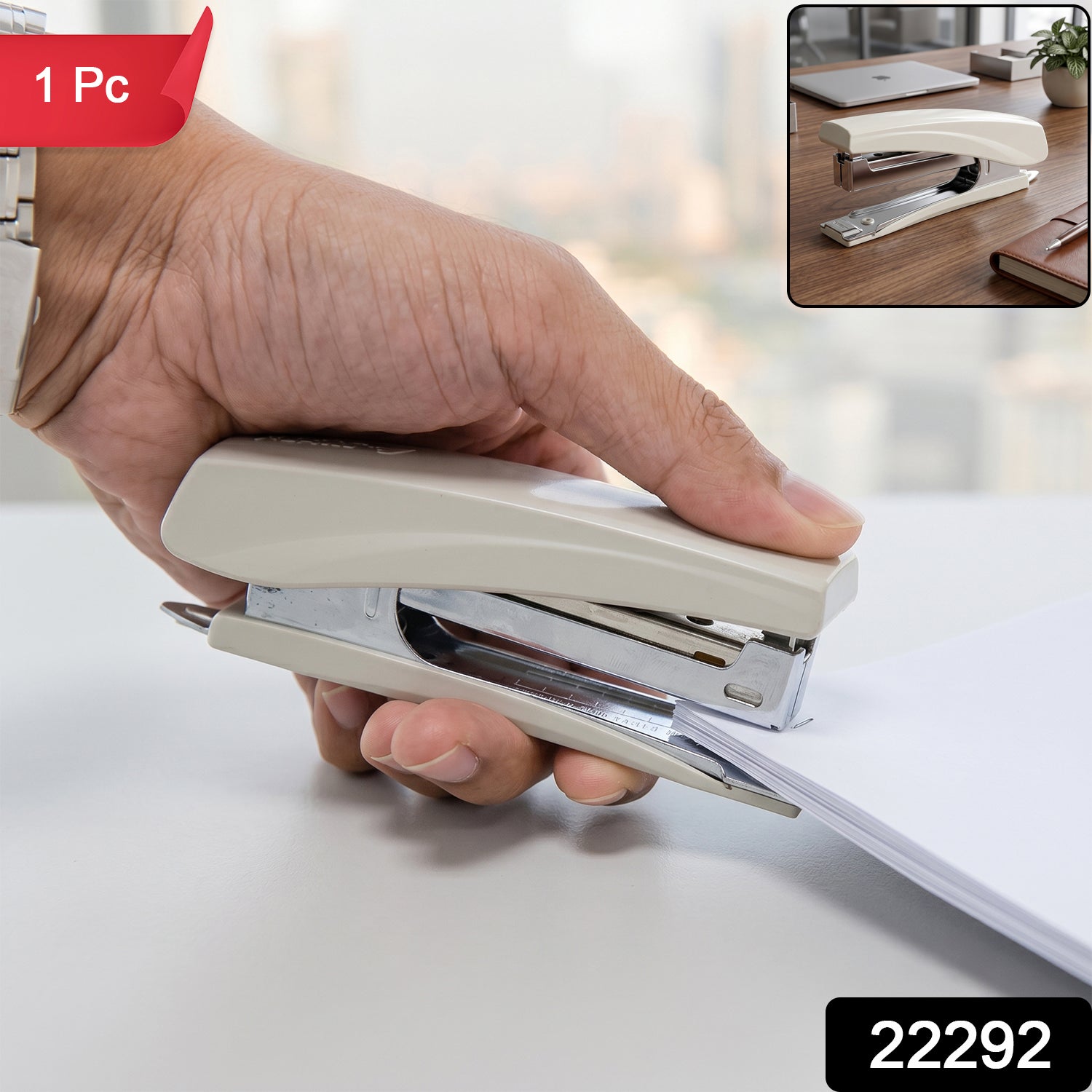 A hand staples white paper with a beige and silver stapler, with a small inset showing the stapler on a desk.