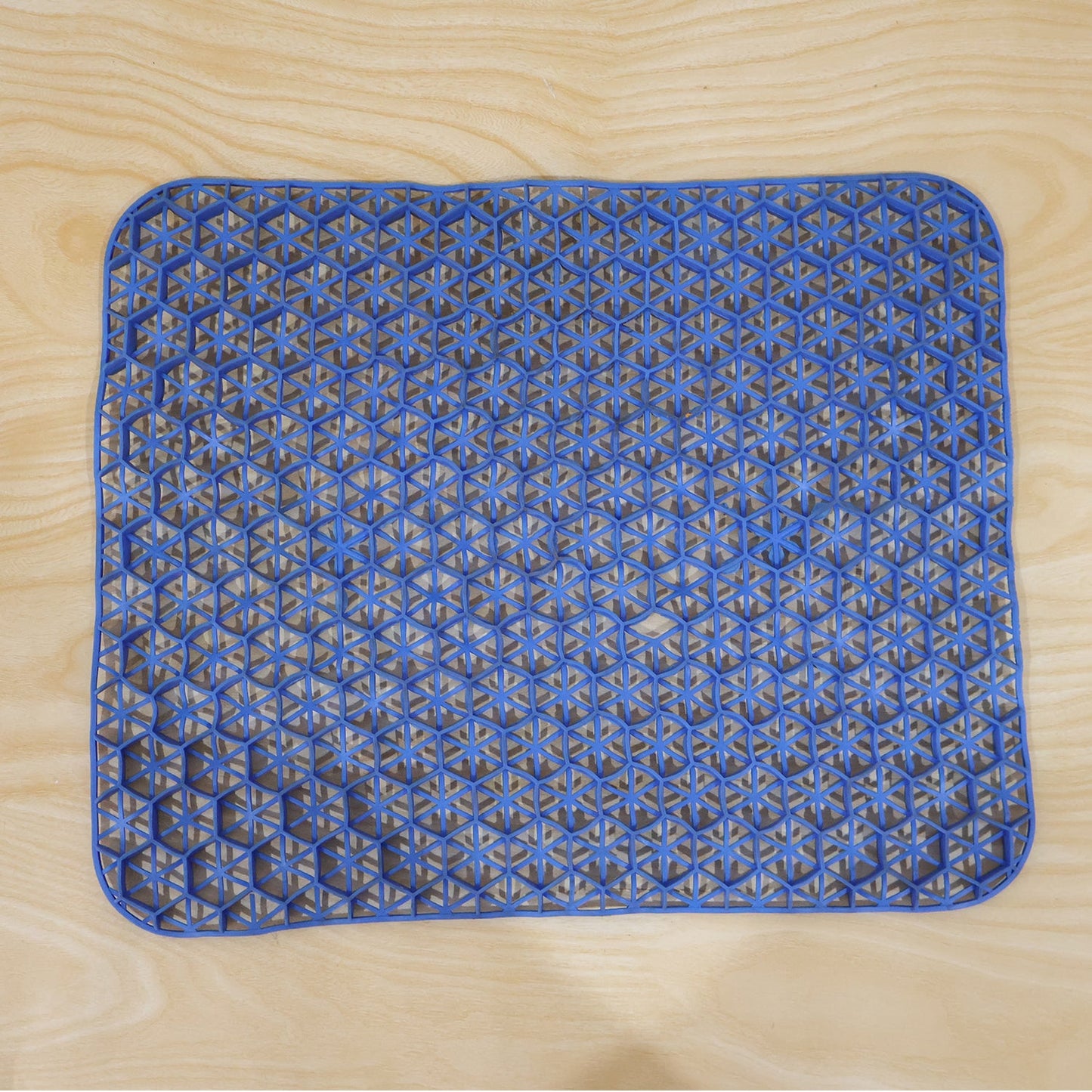 Top-down view of the blue honeycomb gel cushion on a light wooden surface.
