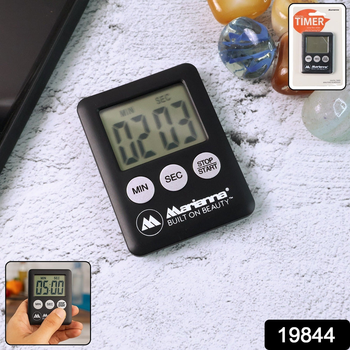 A black digital timer showing 02:03 on a textured surface with decorative marbles and a small packaged timer.