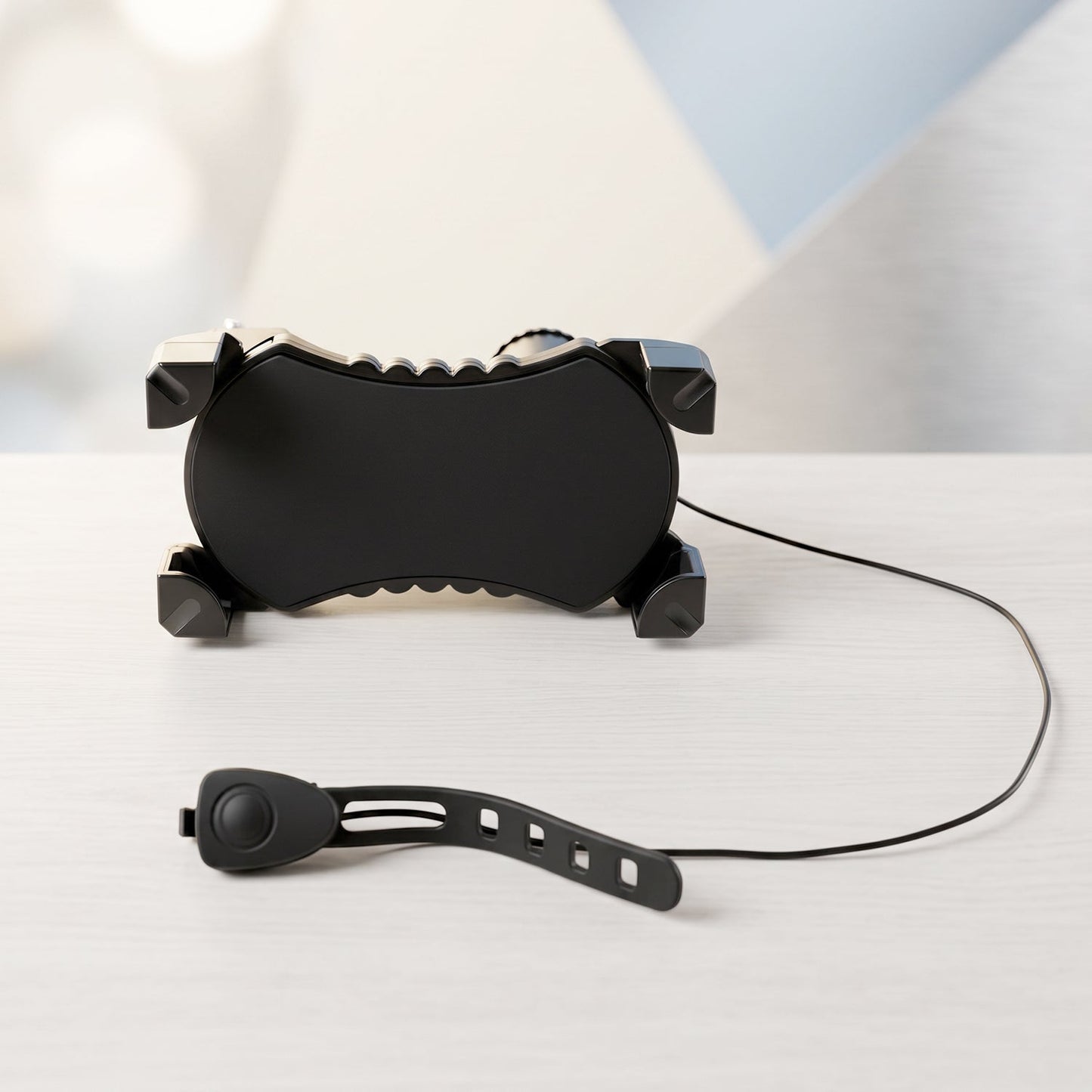 A black bicycle phone holder and a separate horn with a strap are displayed on a light wooden surface.
