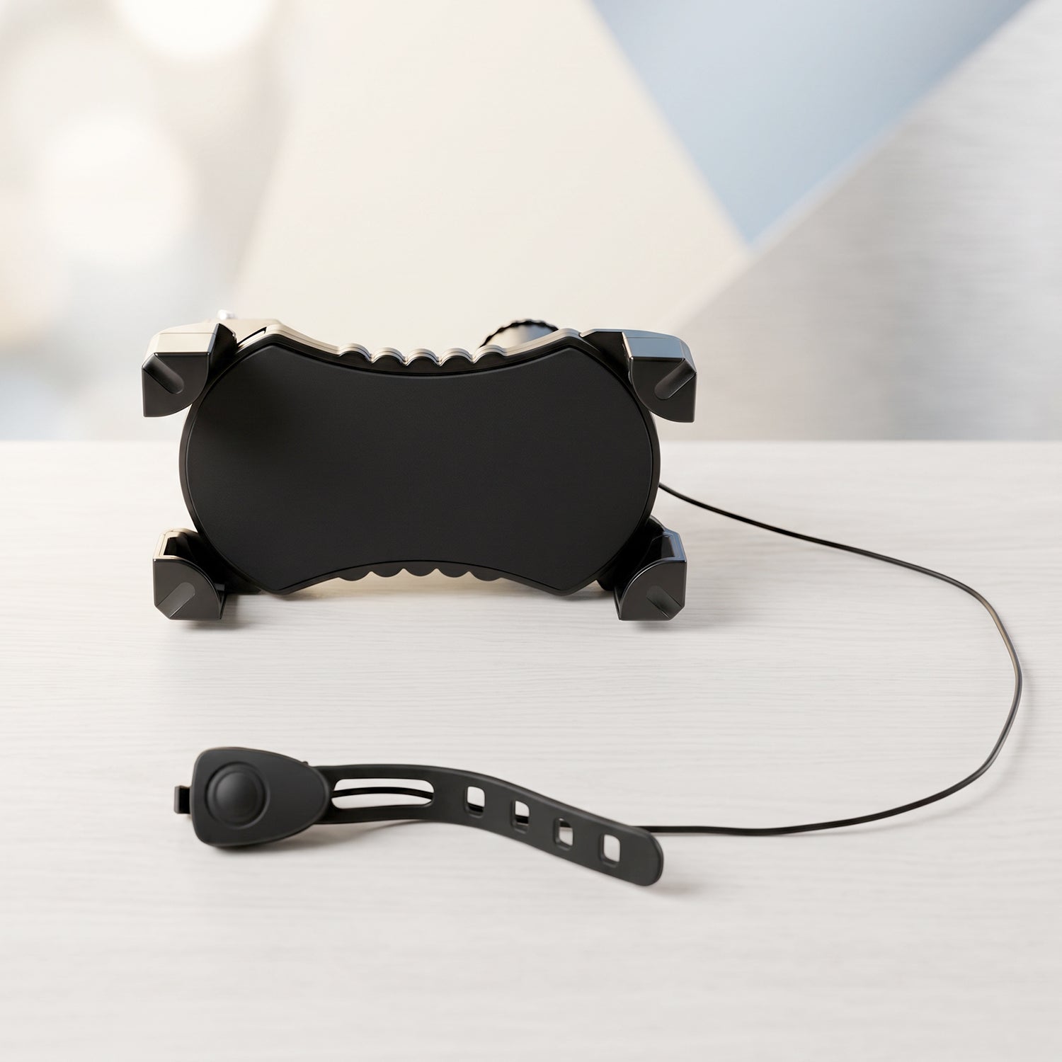A black bicycle phone holder and a separate horn with a strap are displayed on a light wooden surface.