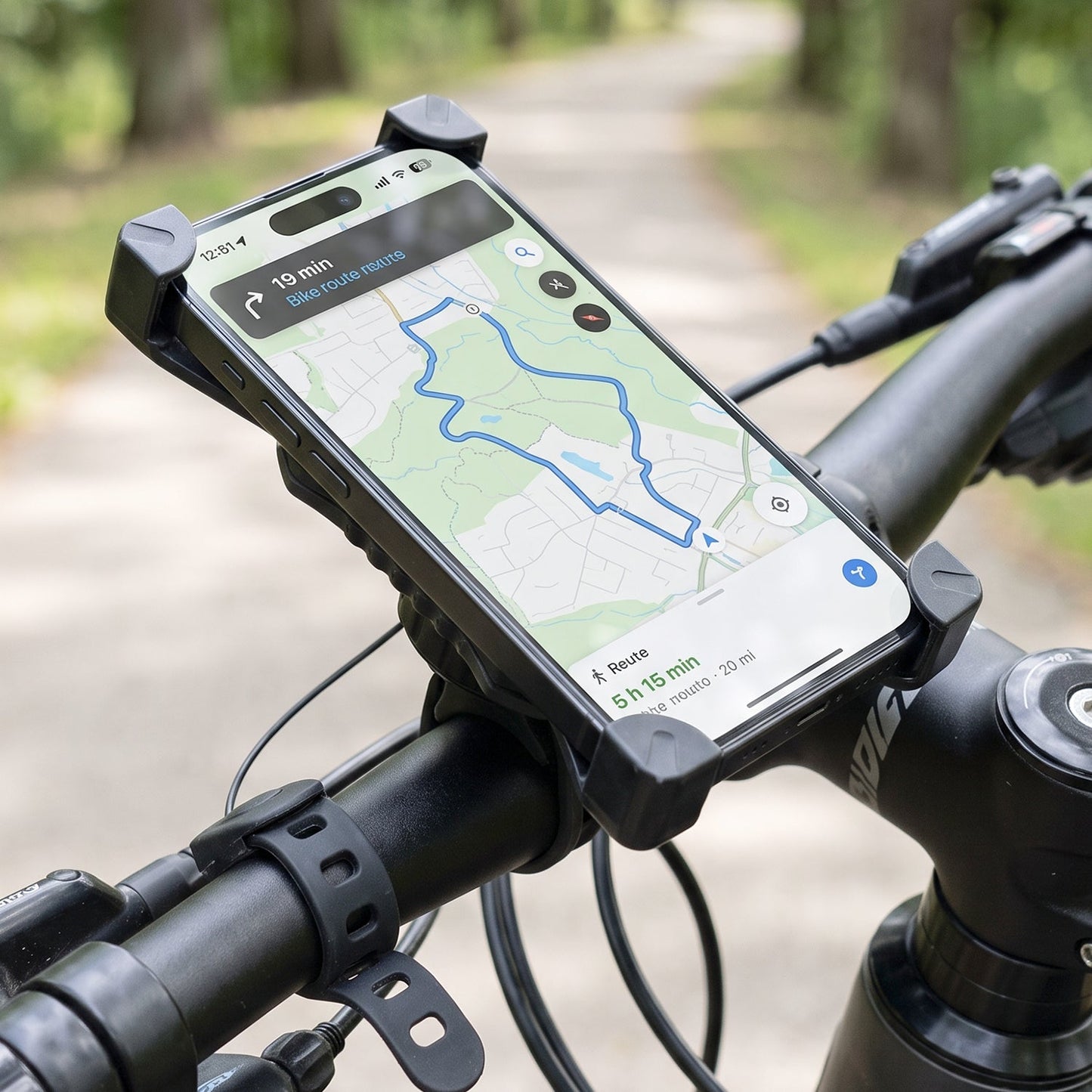 A black phone holder with a phone displaying a bike route map is securely mounted on bicycle handlebars.
