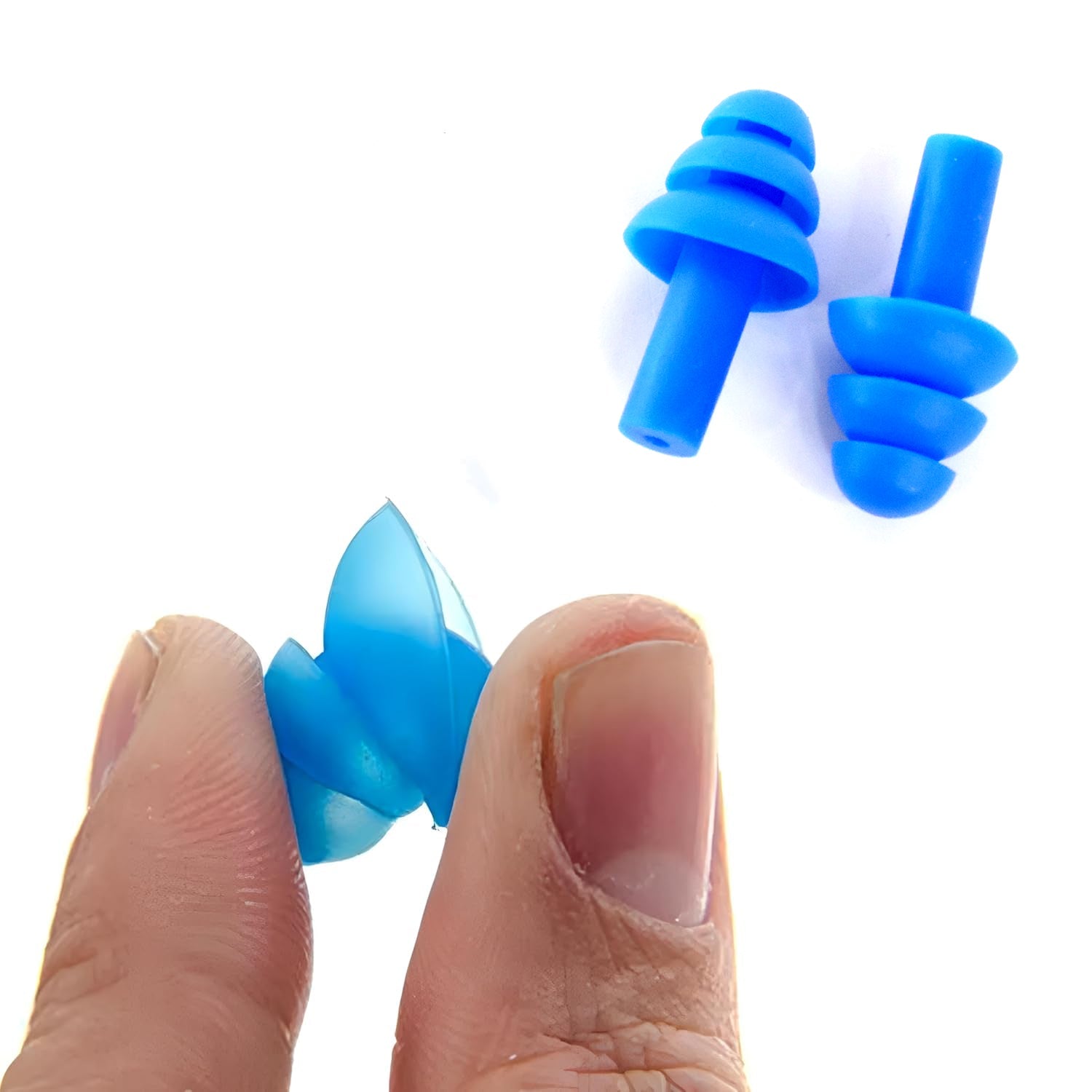 A person's fingers hold a blue silicone earplug, demonstrating its flexibility, with two more earplugs in the background.