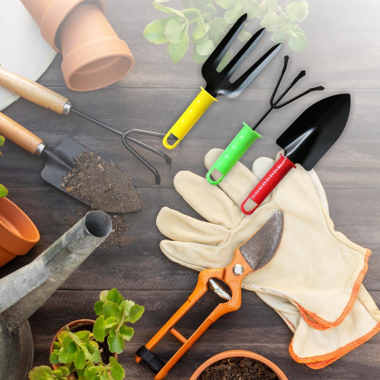 A yellow fork, green cultivator, and red trowel are among various gardening tools and gloves on a wooden surface.