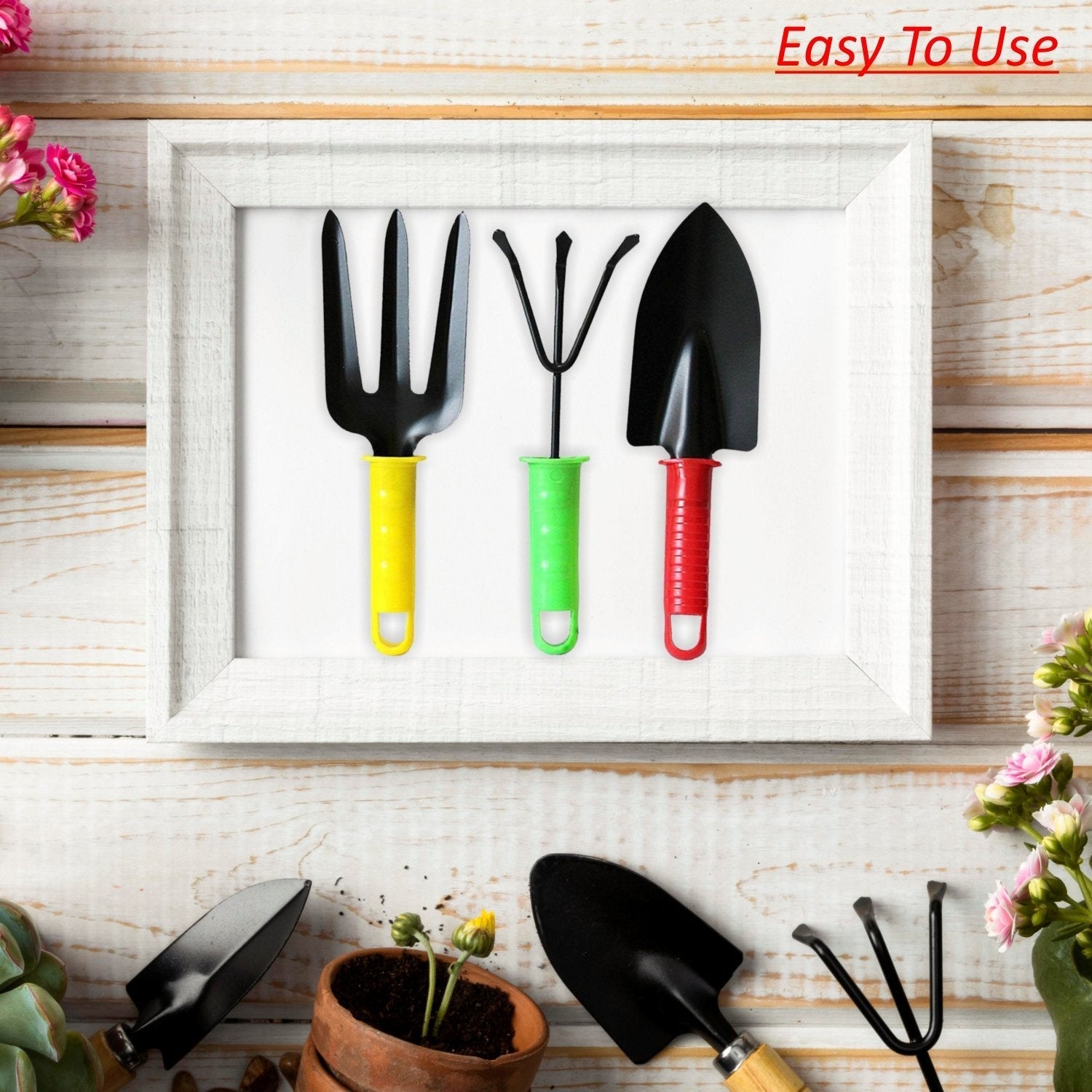 A yellow fork, green cultivator, and red trowel are neatly framed in white, with gardening items scattered around.