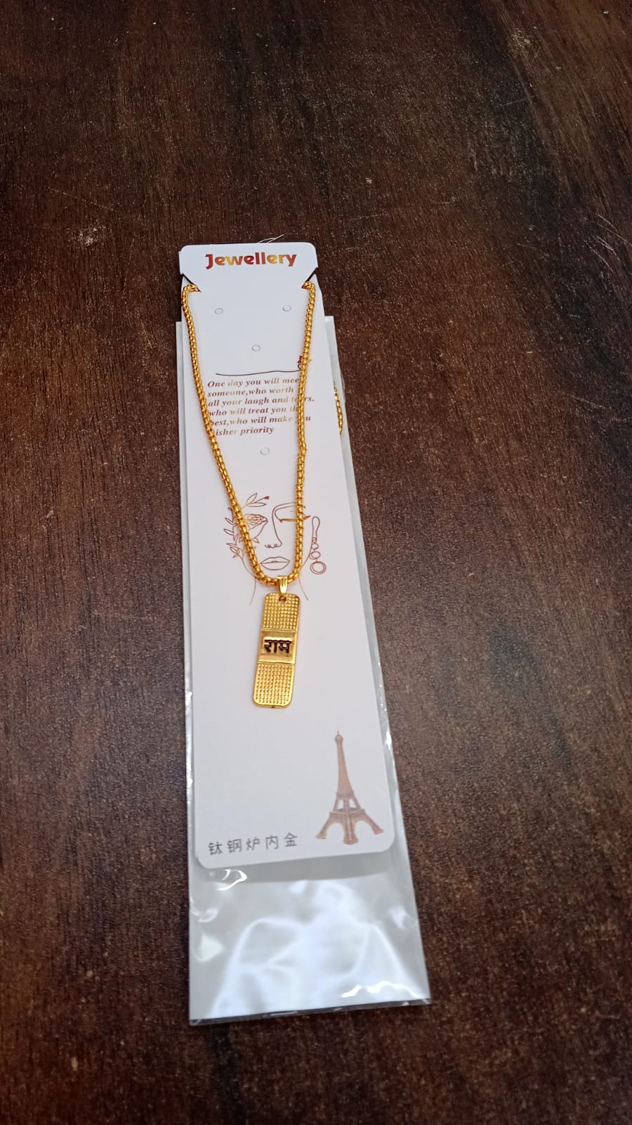 The spiritual gold plated Ram Naam locket presented on a simple surface.