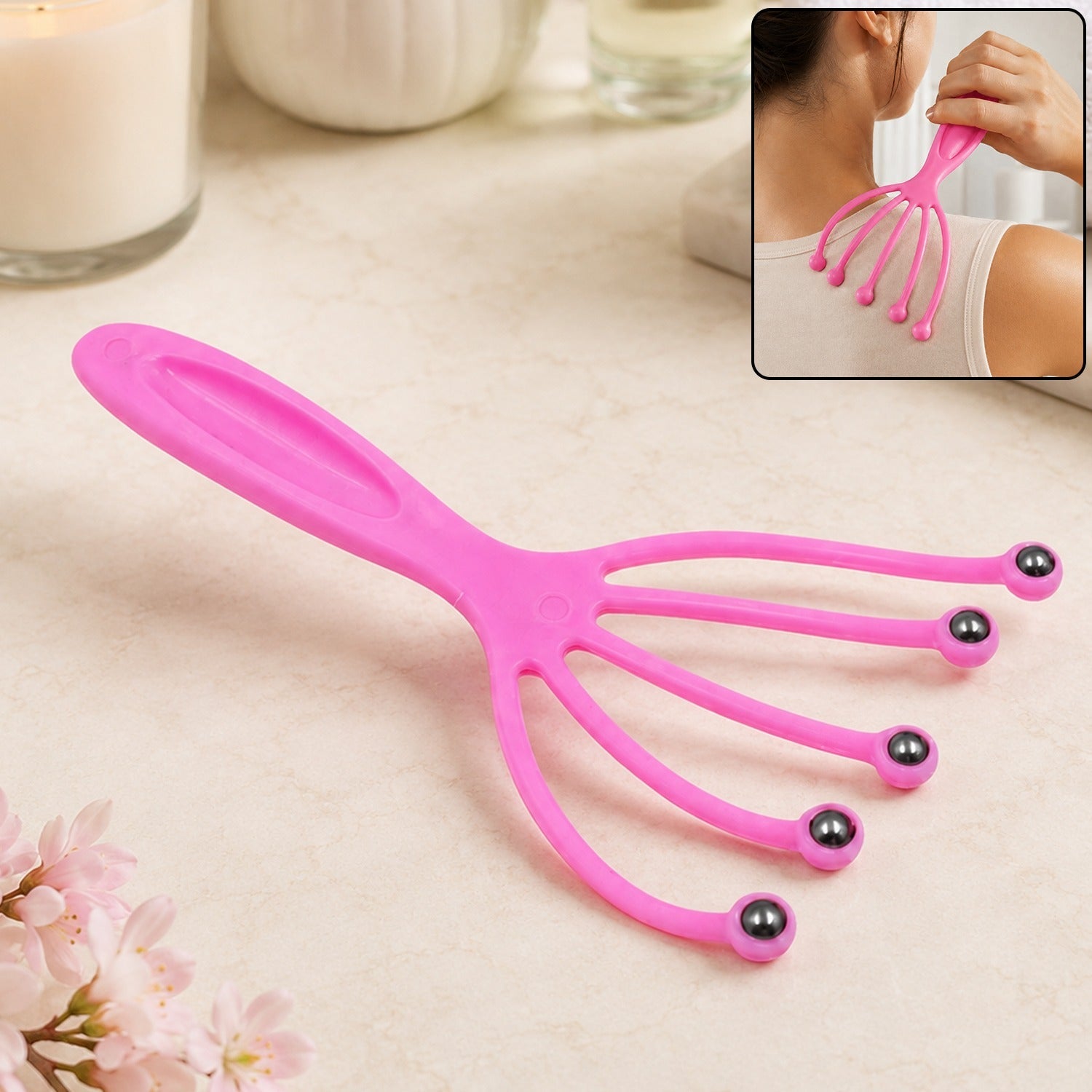 A pink plastic scalp massager with five flexible arms ending in metal roller balls, shown with an inset of a person using it