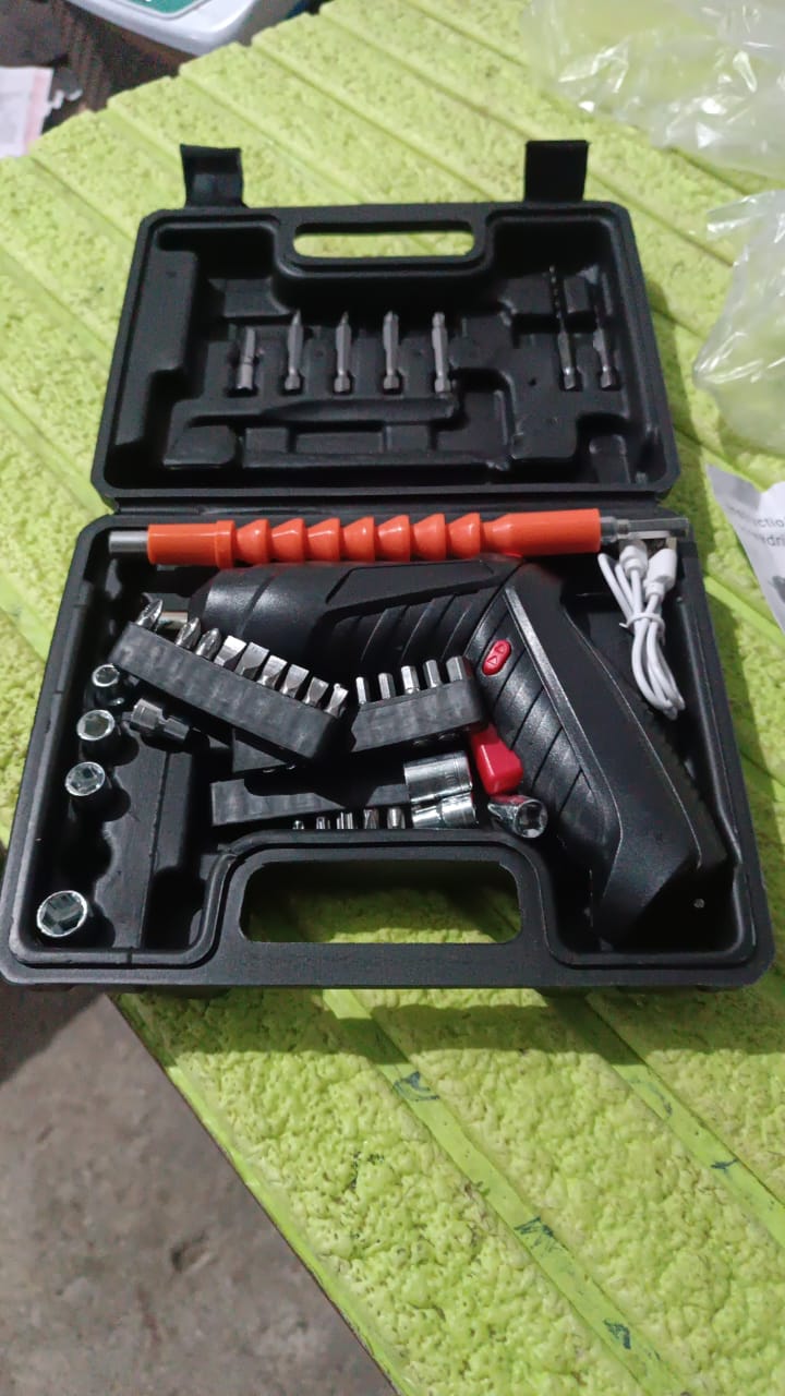 A black carrying case filled with a black and red electric screwdriver, various bits, and a white charging cable is open on
