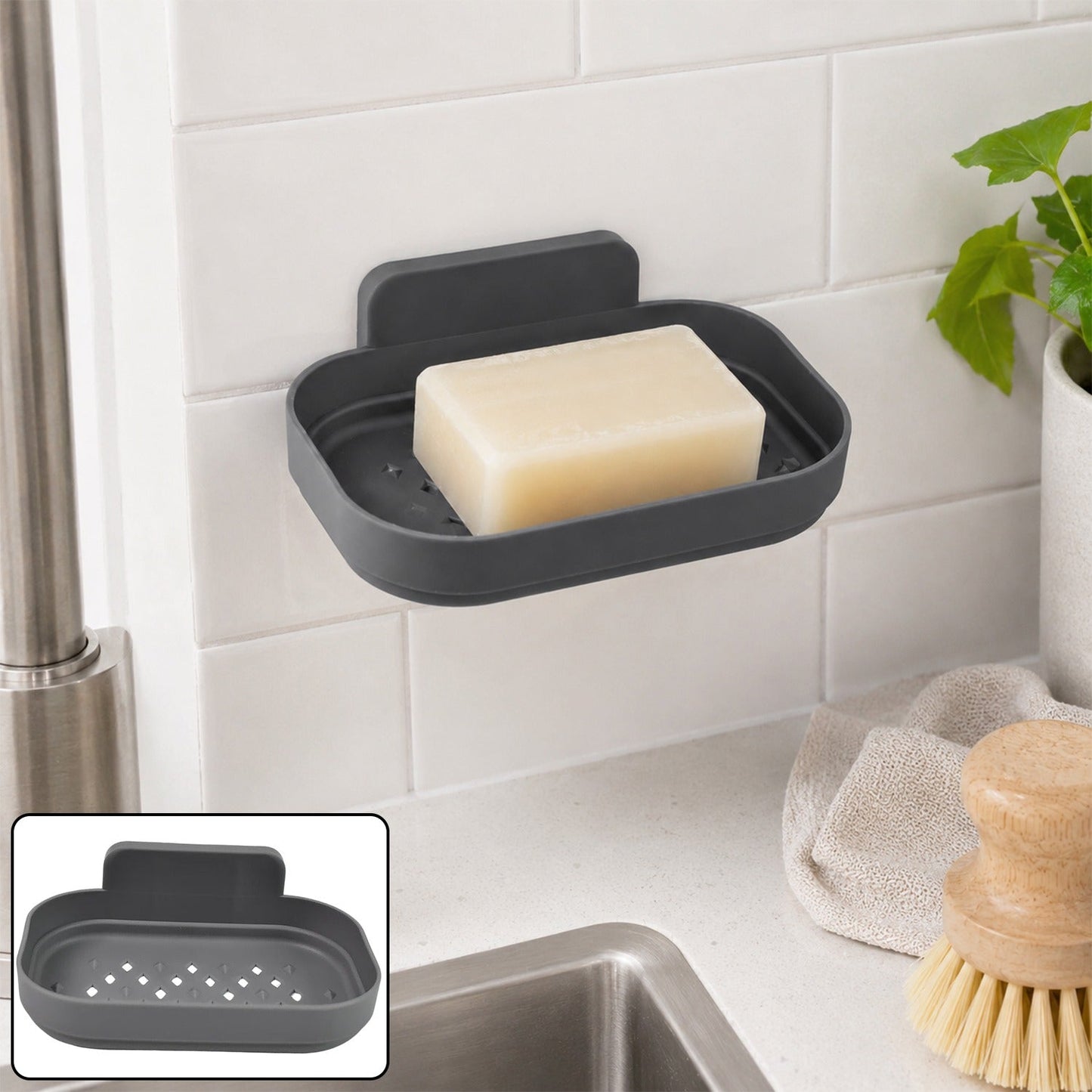 A dark gray self-adhesive soap dish with a bar of soap is mounted on white subway tiles above a sink.