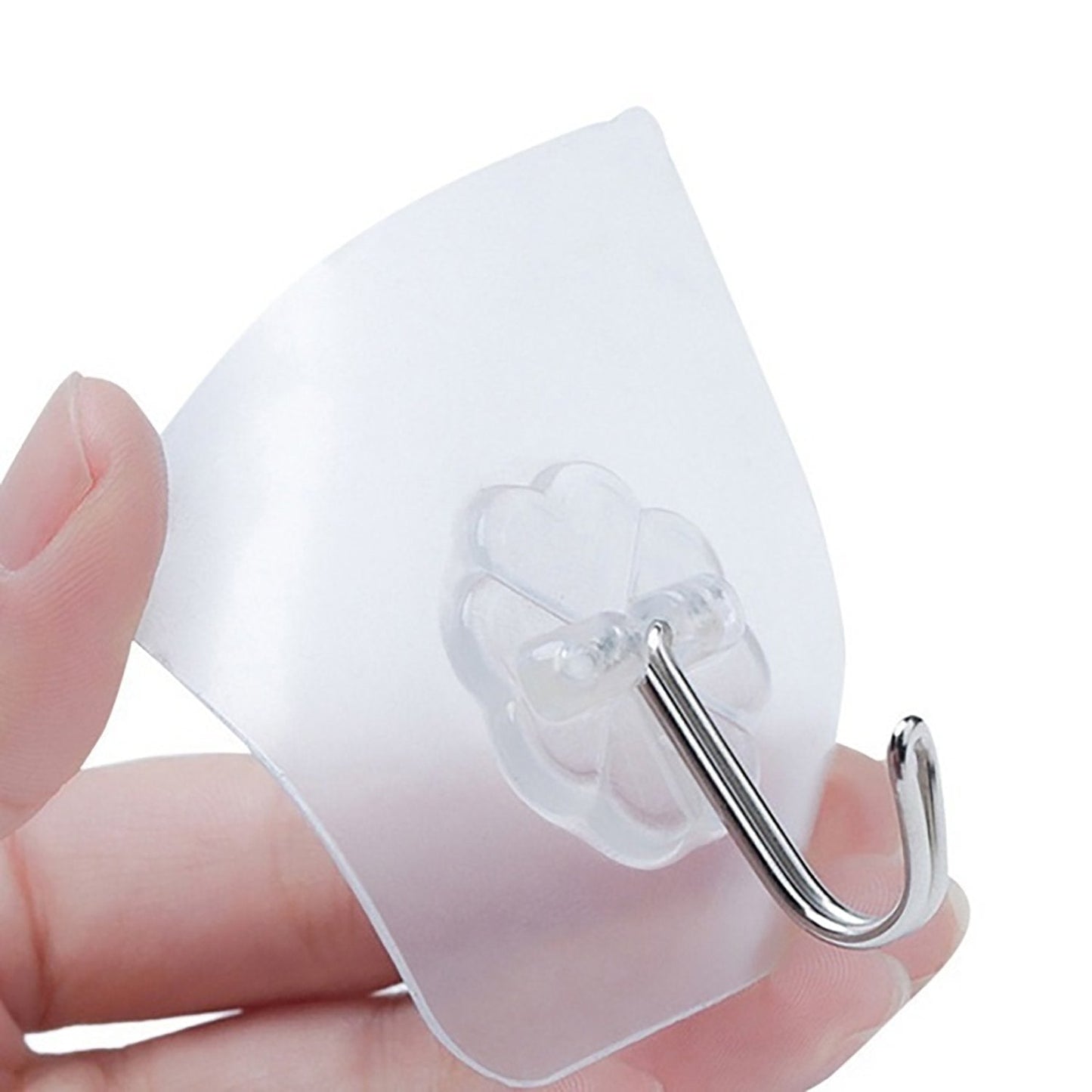 A hand holds a single transparent adhesive hook with a silver stainless steel hook, showing its clear material and design.