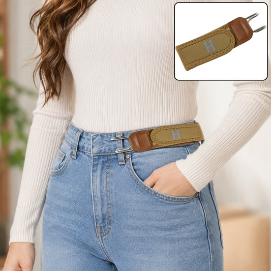 A woman wears light blue jeans and a white top with a camel-colored elastic belt featuring a gray 'H' and silver hooks.