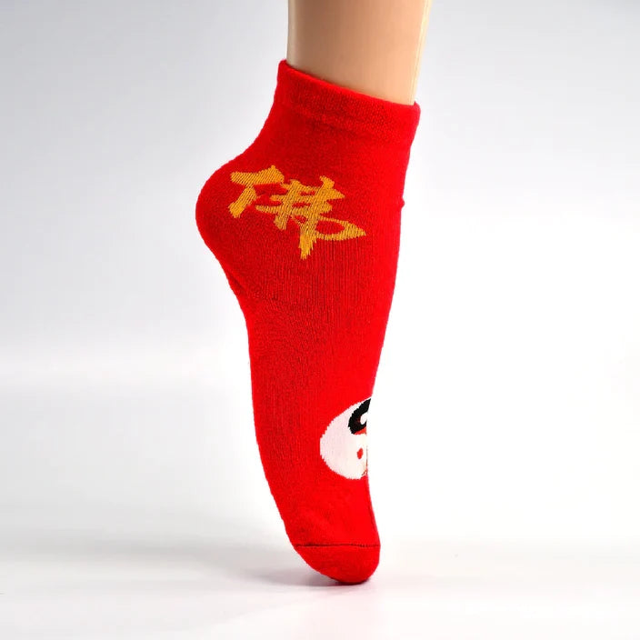 A mannequin foot wearing a red crew sock with a yellow Chinese character and a black and white yin-yang symbol.