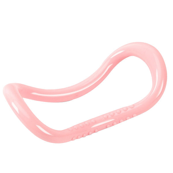 A single pink pilates ring with textured bumps on the inner curves, on a white background.