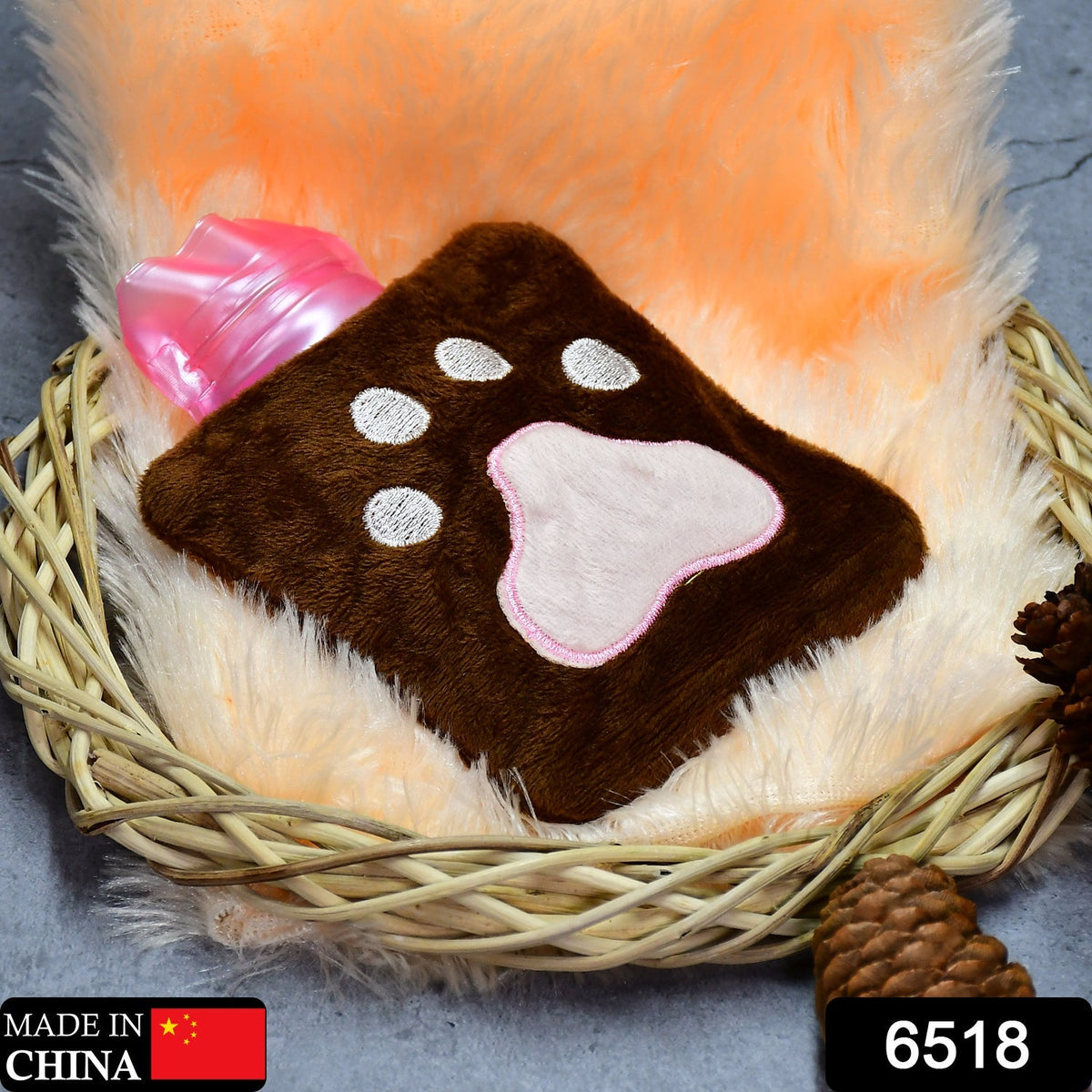 A brown paw print hot water bag sits in a wicker basket with a fluffy orange liner.