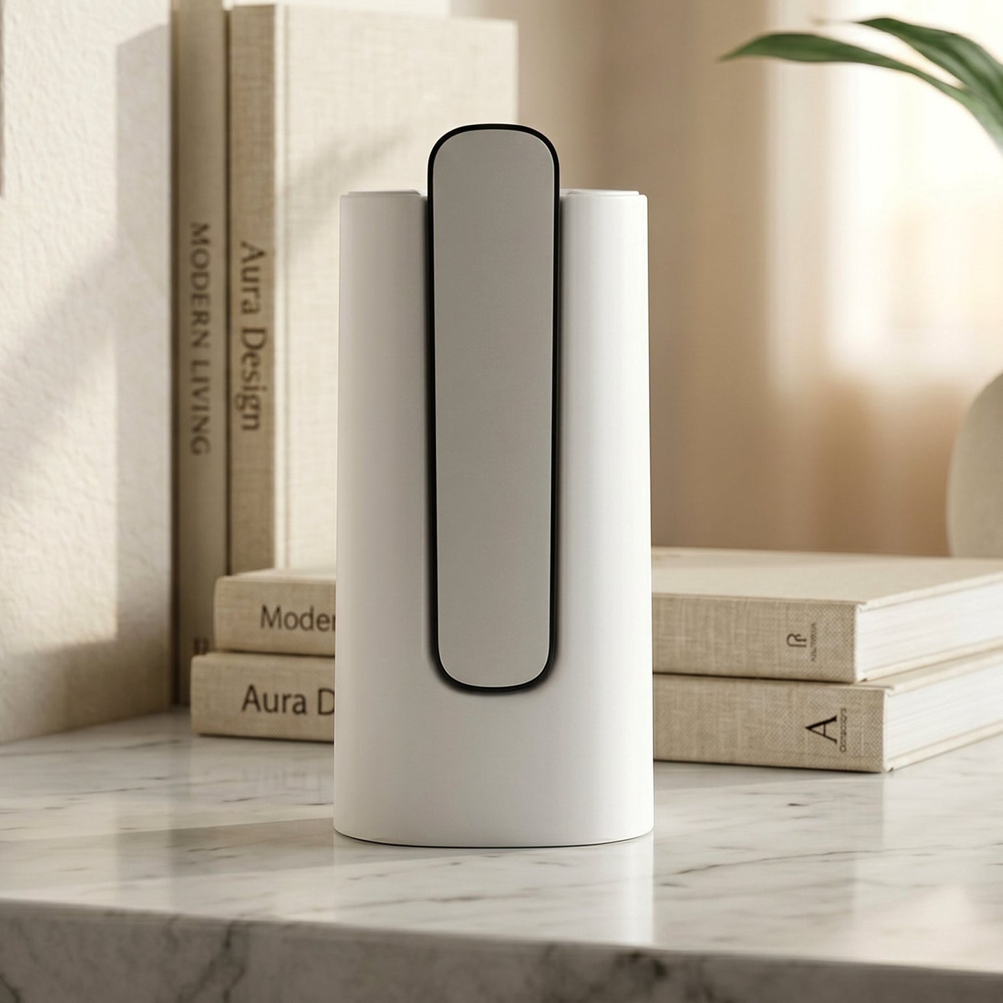A white and gray foldable water dispenser stands on a marble surface in front of a stack of books and a plant.