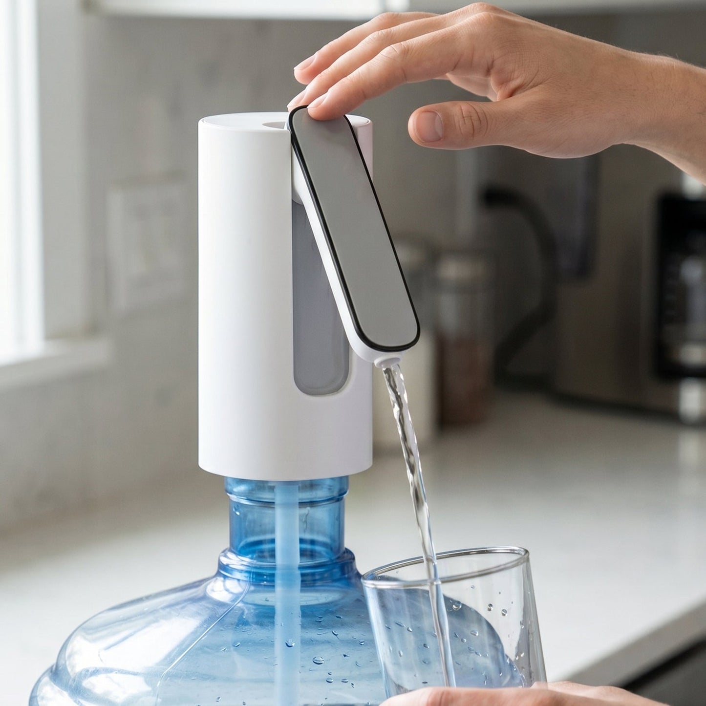 A close-up of a person's hand pressing a button on a white and gray foldable water dispenser, filling a glass with water