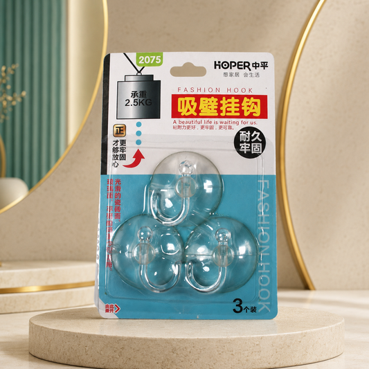 Three transparent suction cup hooks in retail packaging, displayed on a beige pedestal with a mirror in the background.