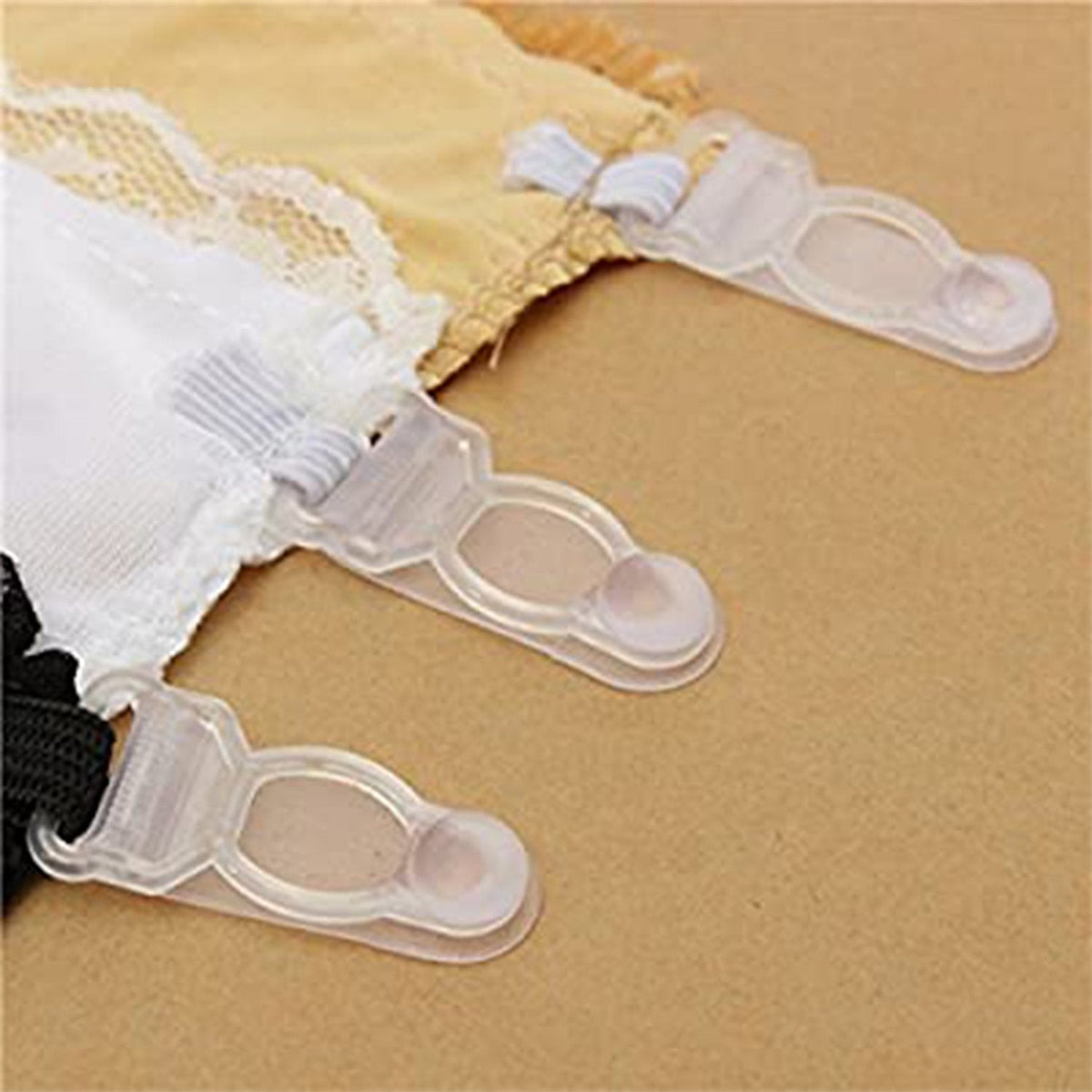 Close-up of the plastic clips on the black, white, and beige lace-trimmed modesty camisoles.