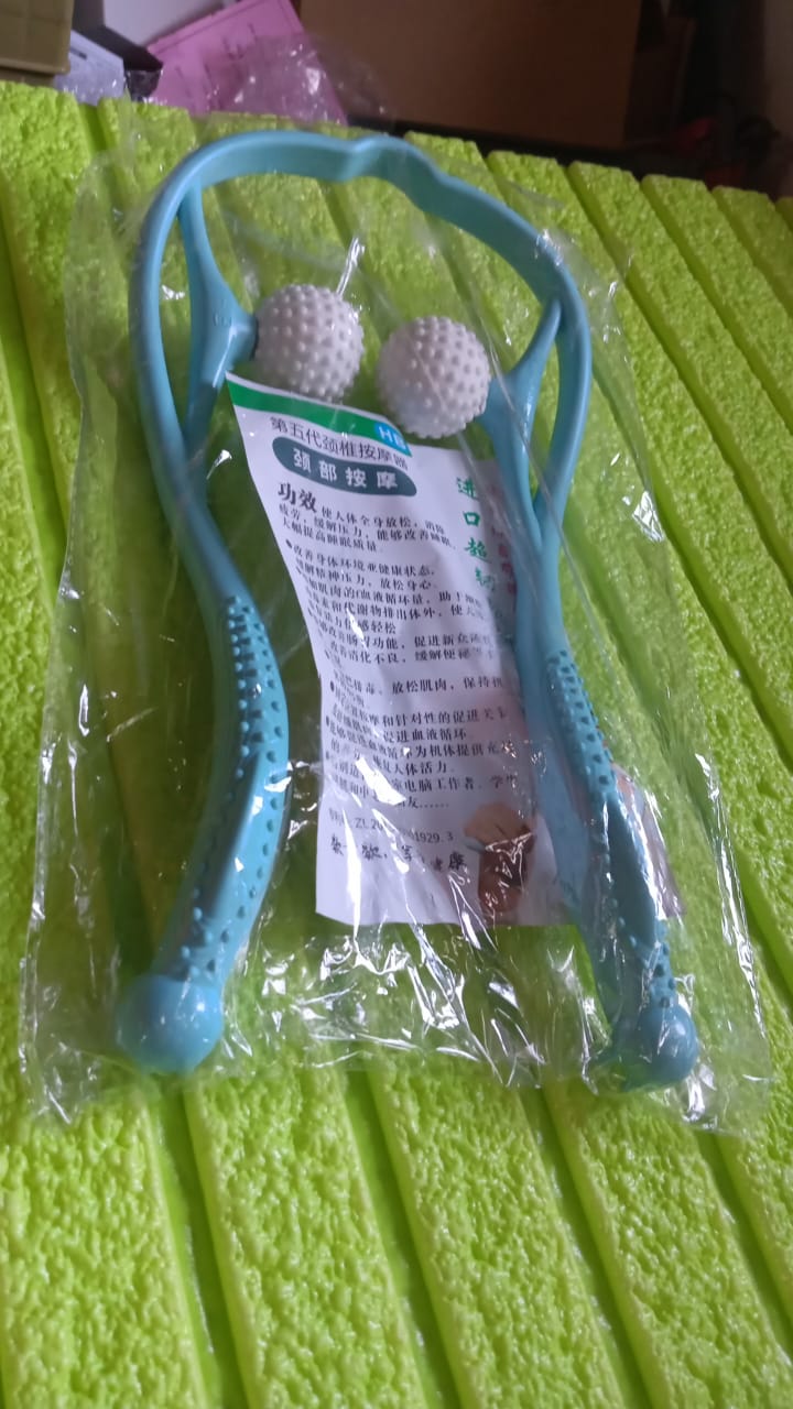 Blue U-shaped neck and shoulder massager wrapped comfortably around a user's neck.