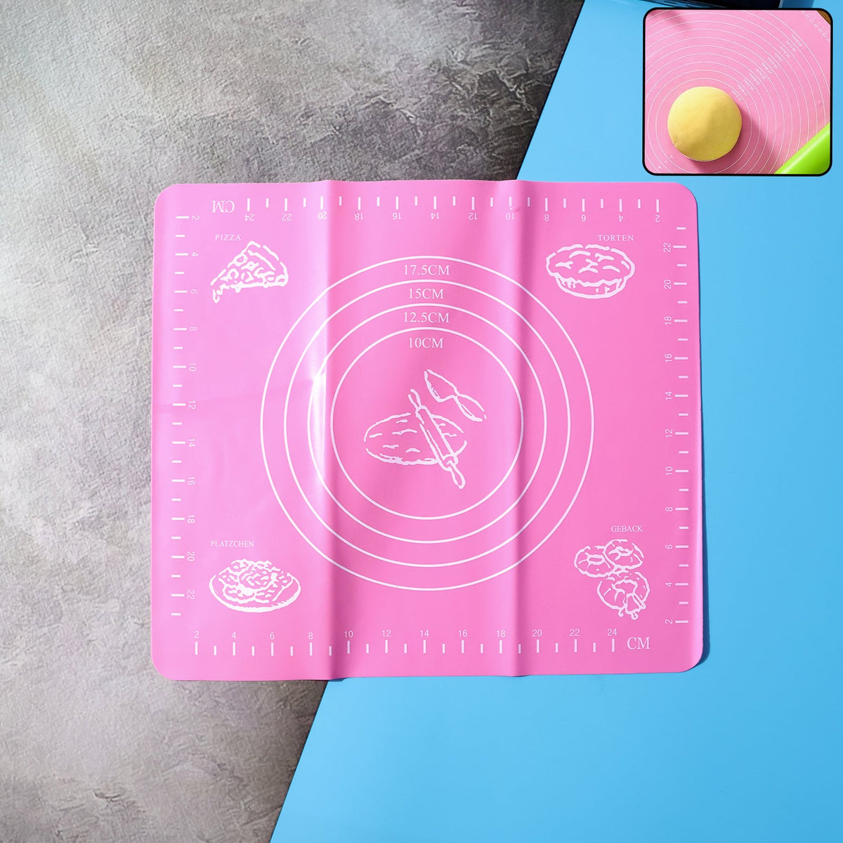 Pink silicone baking mat with white measurement guides and baking illustrations, with a small inset showing dough.