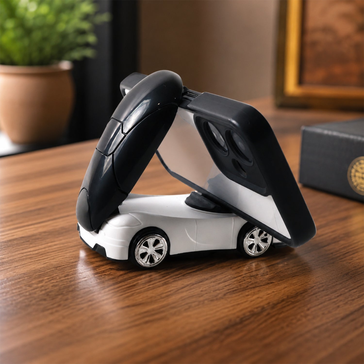A white car-shaped phone holder with a black top holds a phone on a wooden table.