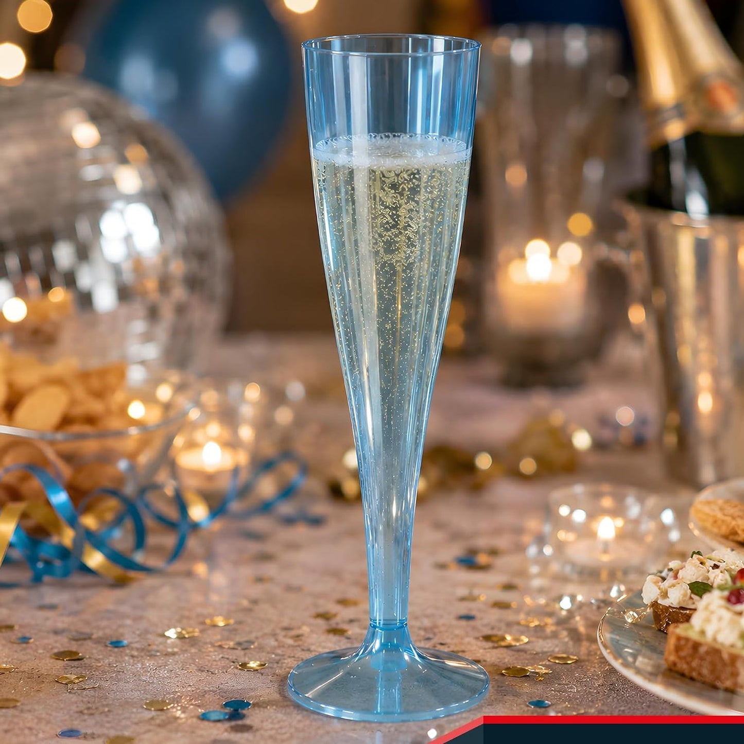 A blue plastic champagne flute filled with bubbly liquid on a festive table with party decorations.