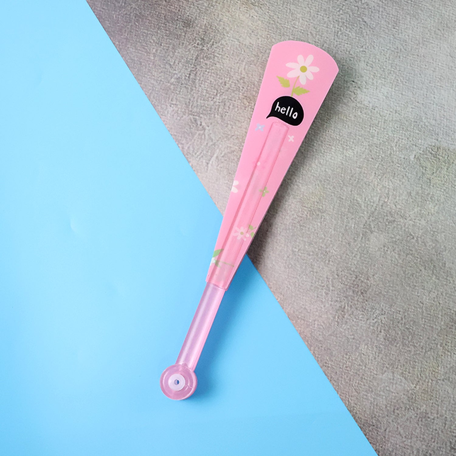 A closed pink fan with a white flower and