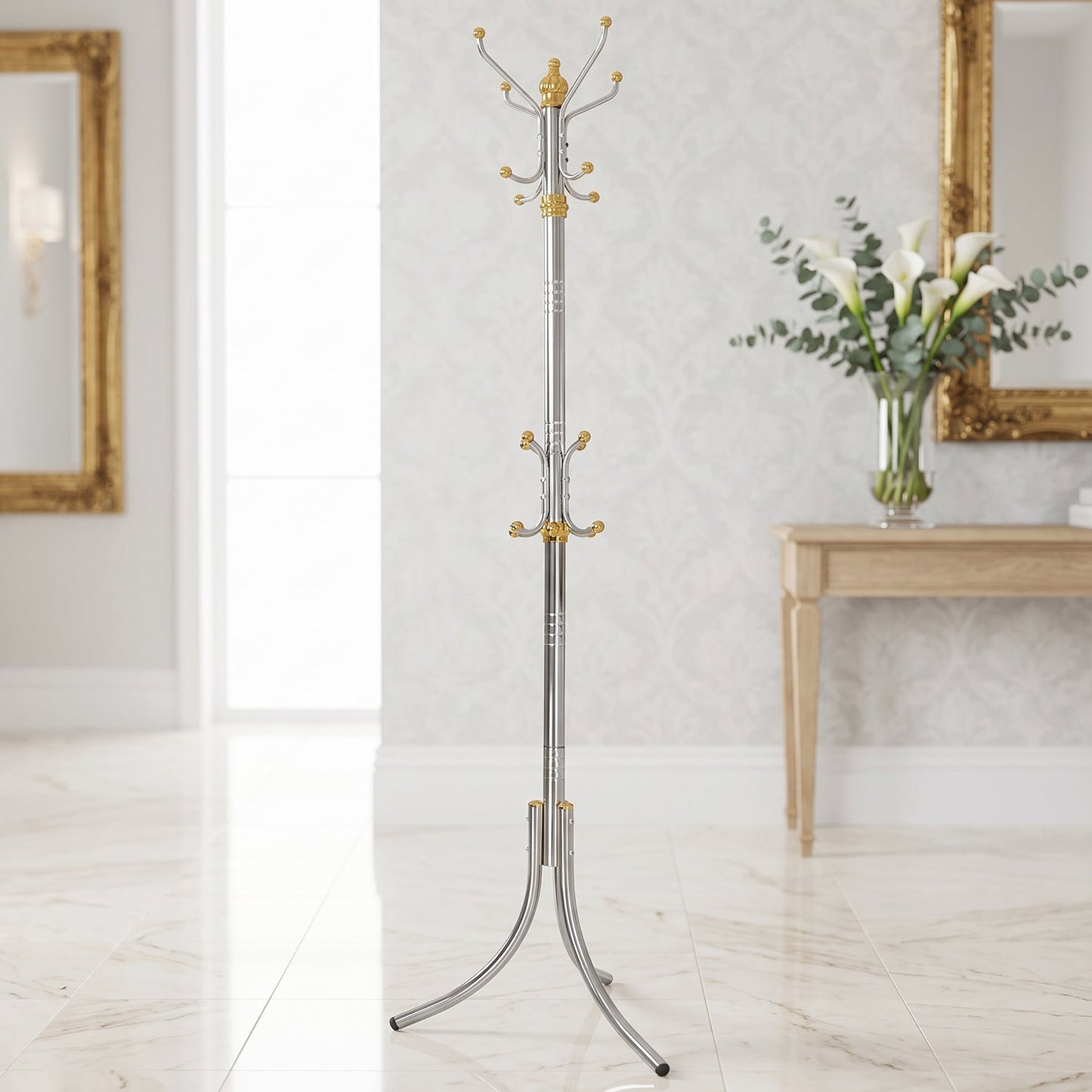 A tall, silver-colored metal clothes hanger stand with gold accents and multiple hooks stands in a room with a large mirror