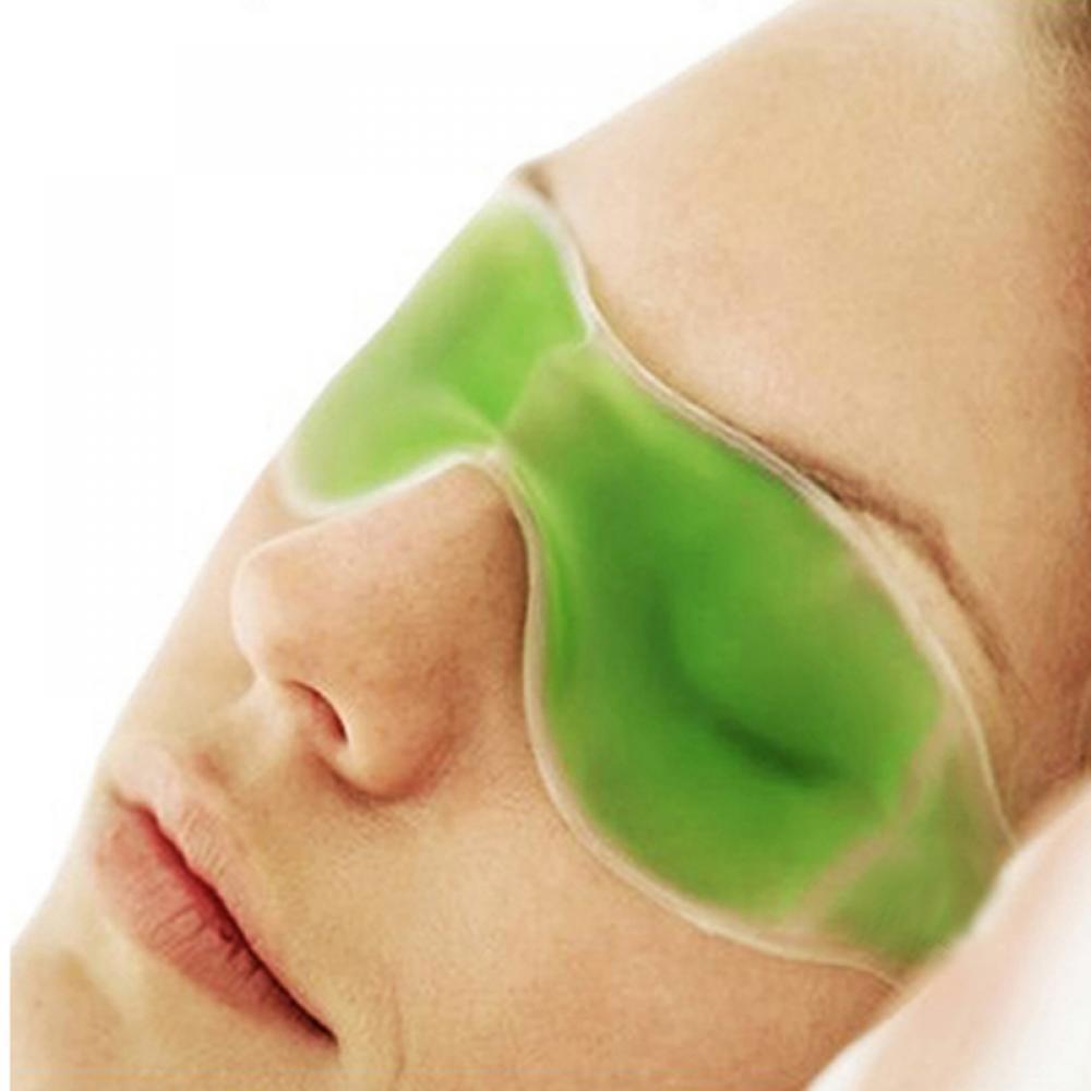 Close-up of a person's face wearing a green gel eye mask, showing the contours around the eyes.