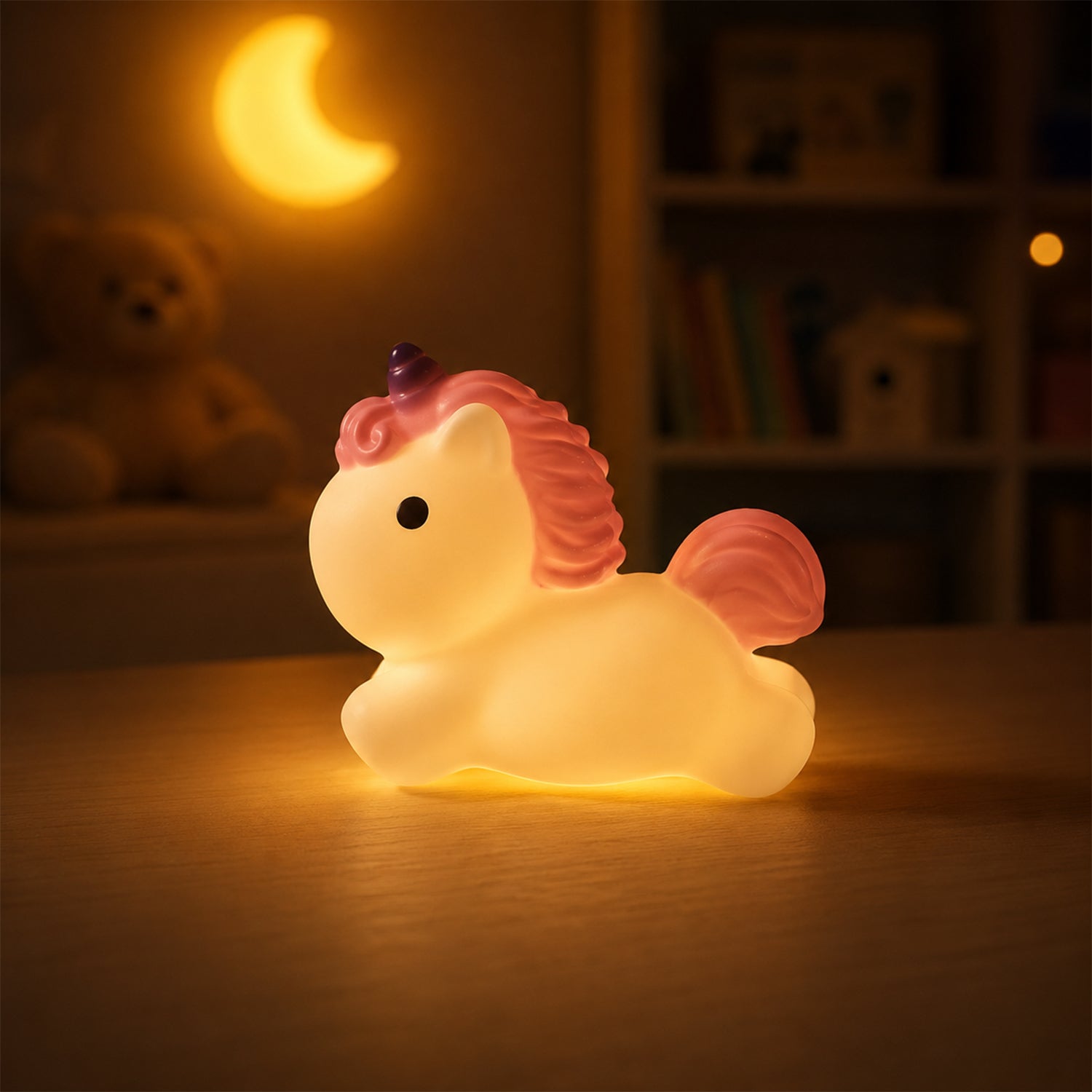 A glowing white unicorn night light with pink mane and tail, and a purple horn, sits on a wooden surface in a dark room with