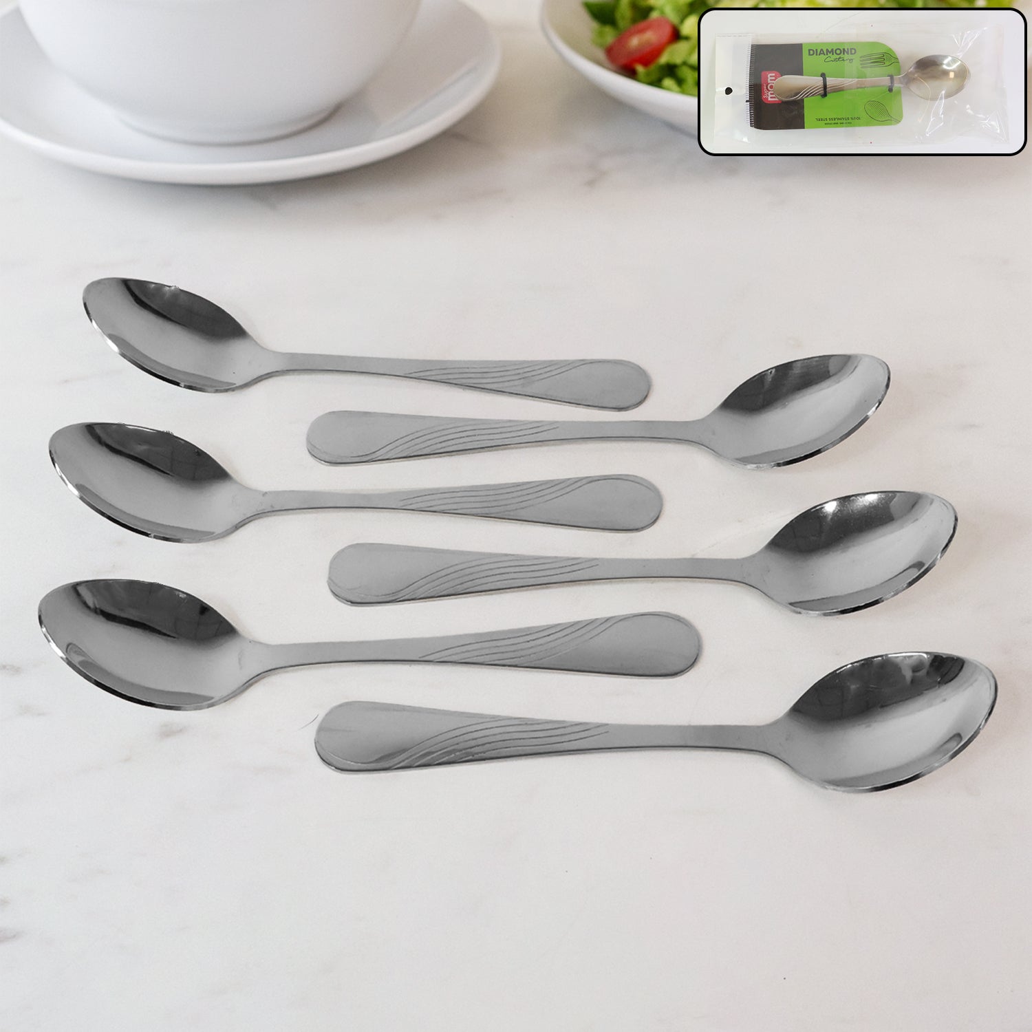 Set of six polished stainless steel dining spoons with elegant engraved handles