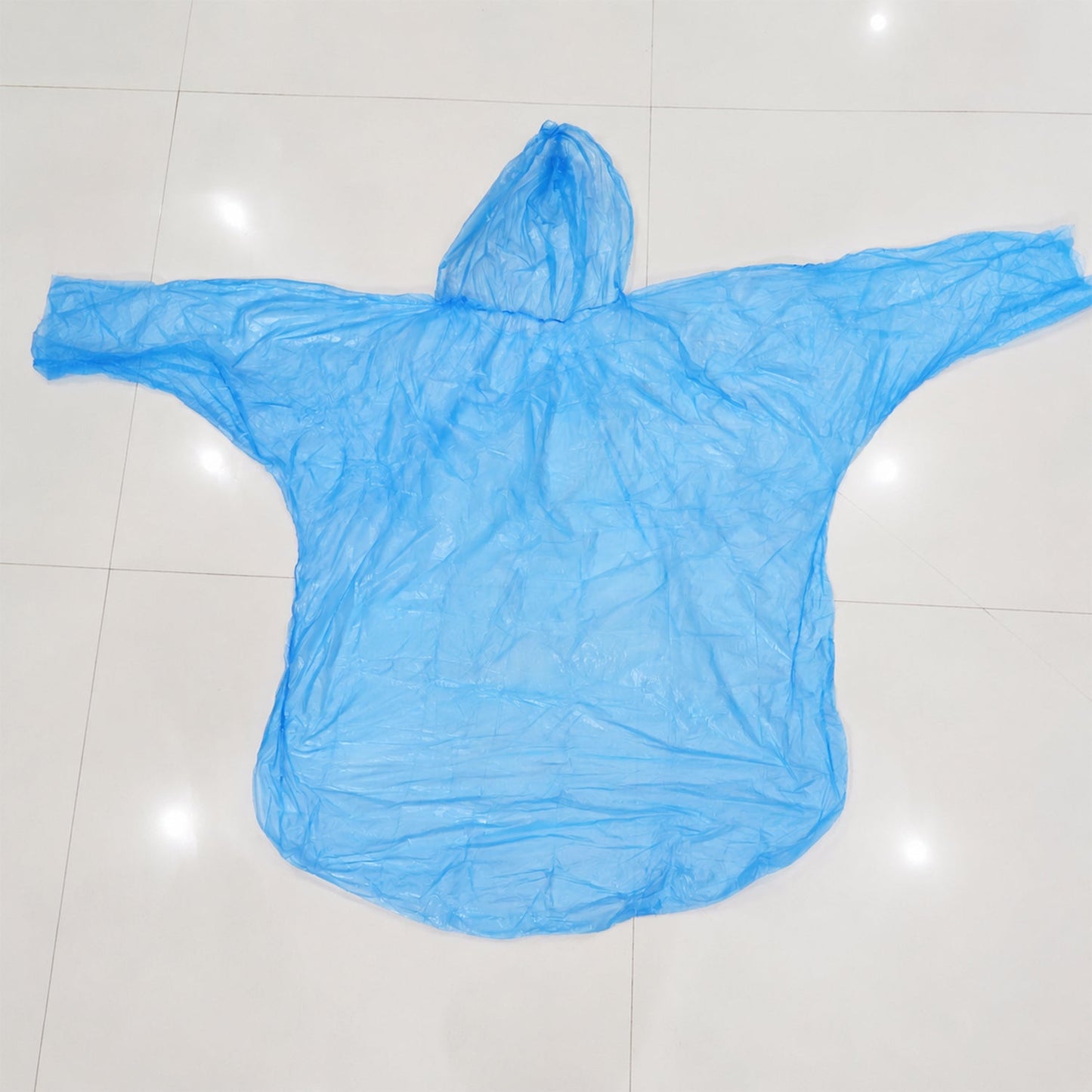 A light blue plastic poncho with a hood is spread flat on a white background, ready for use.