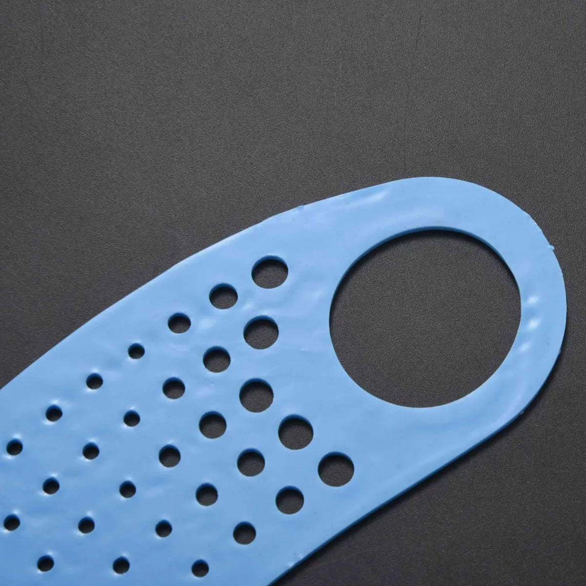 Close-up of the blue silicone strap, showing the perforations and one of the ear loops.