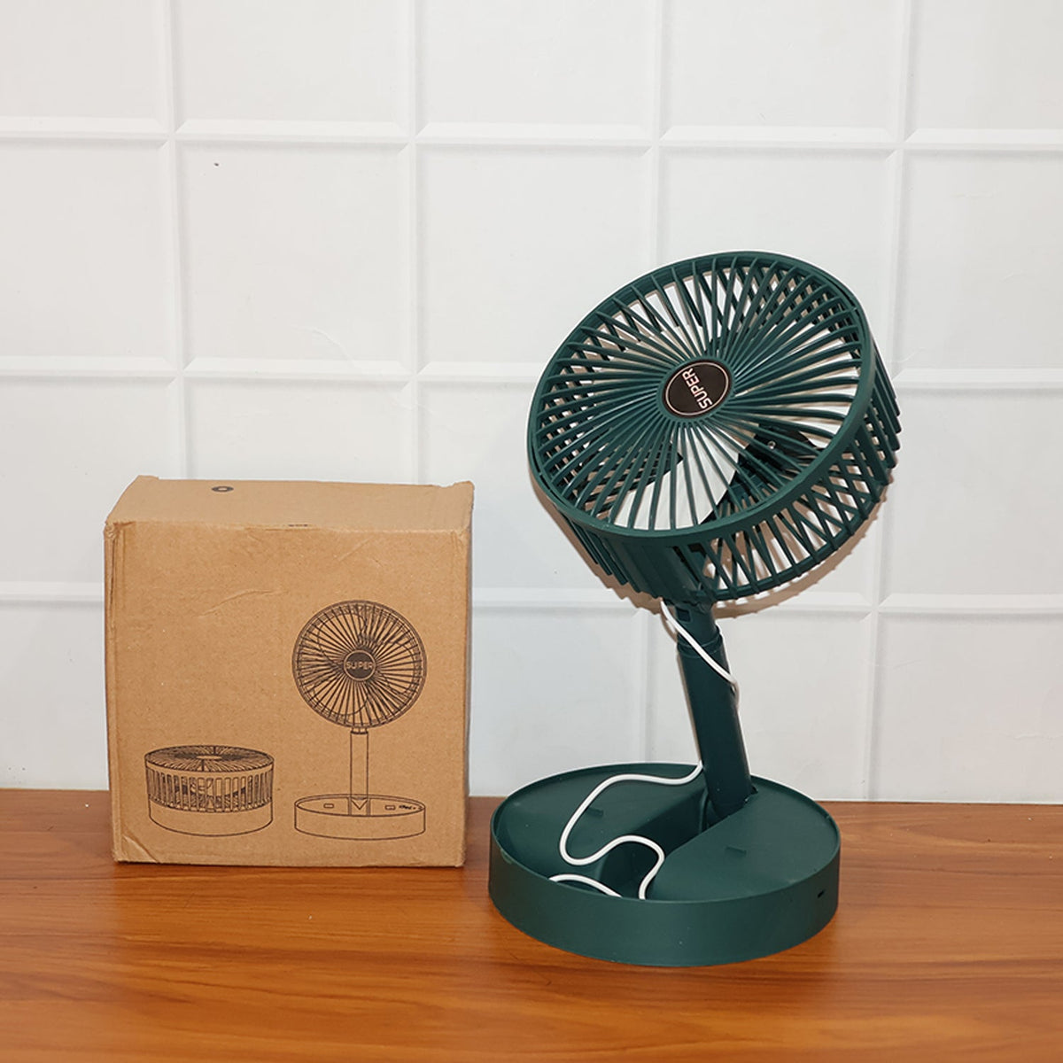 A dark green telescopic foldable mini USB desk fan next to its brown cardboard packaging, showing product illustrations.