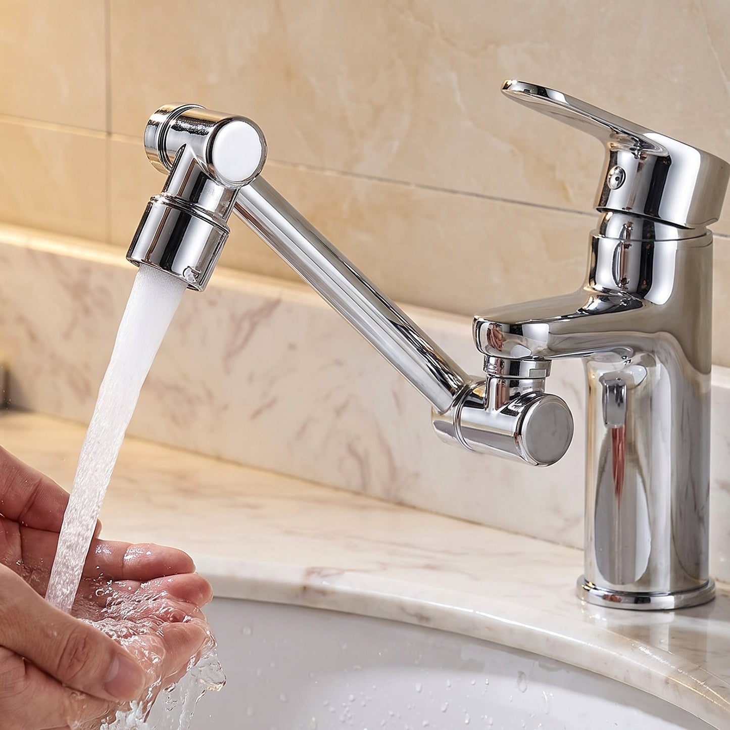 A person washes their hands under a stream of water from a chrome rotatable faucet splash head extension attached to a