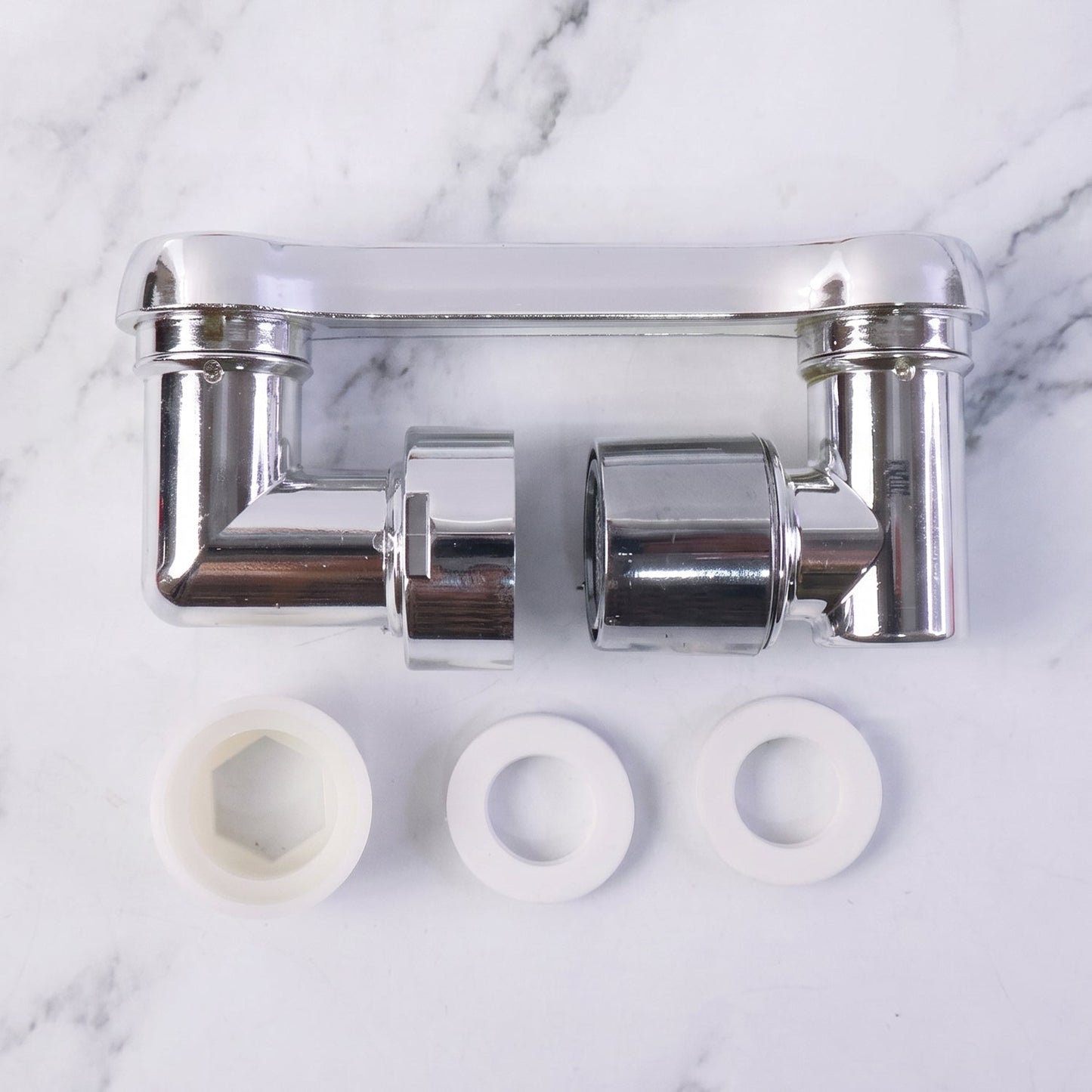 The chrome rotatable faucet splash head extension is displayed in two pieces with three white washers on a white marble