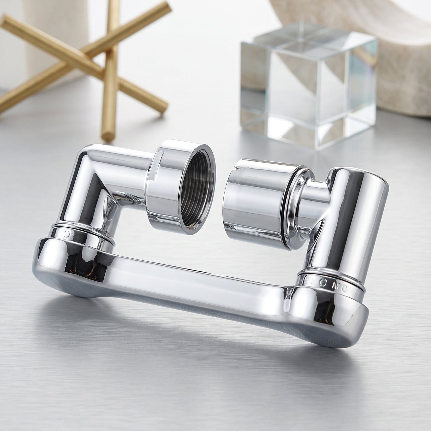 The chrome rotatable faucet splash head extension is displayed in two separate pieces on a metallic surface, with decorative