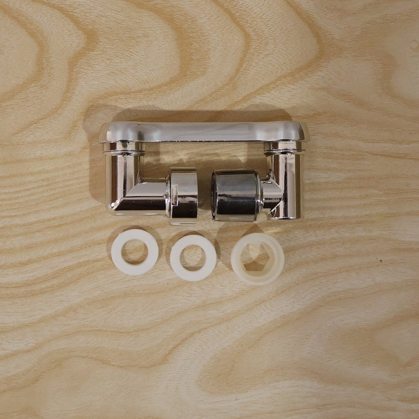 The chrome rotatable faucet splash head extension is shown in two pieces with three white washers on a light wooden surface.