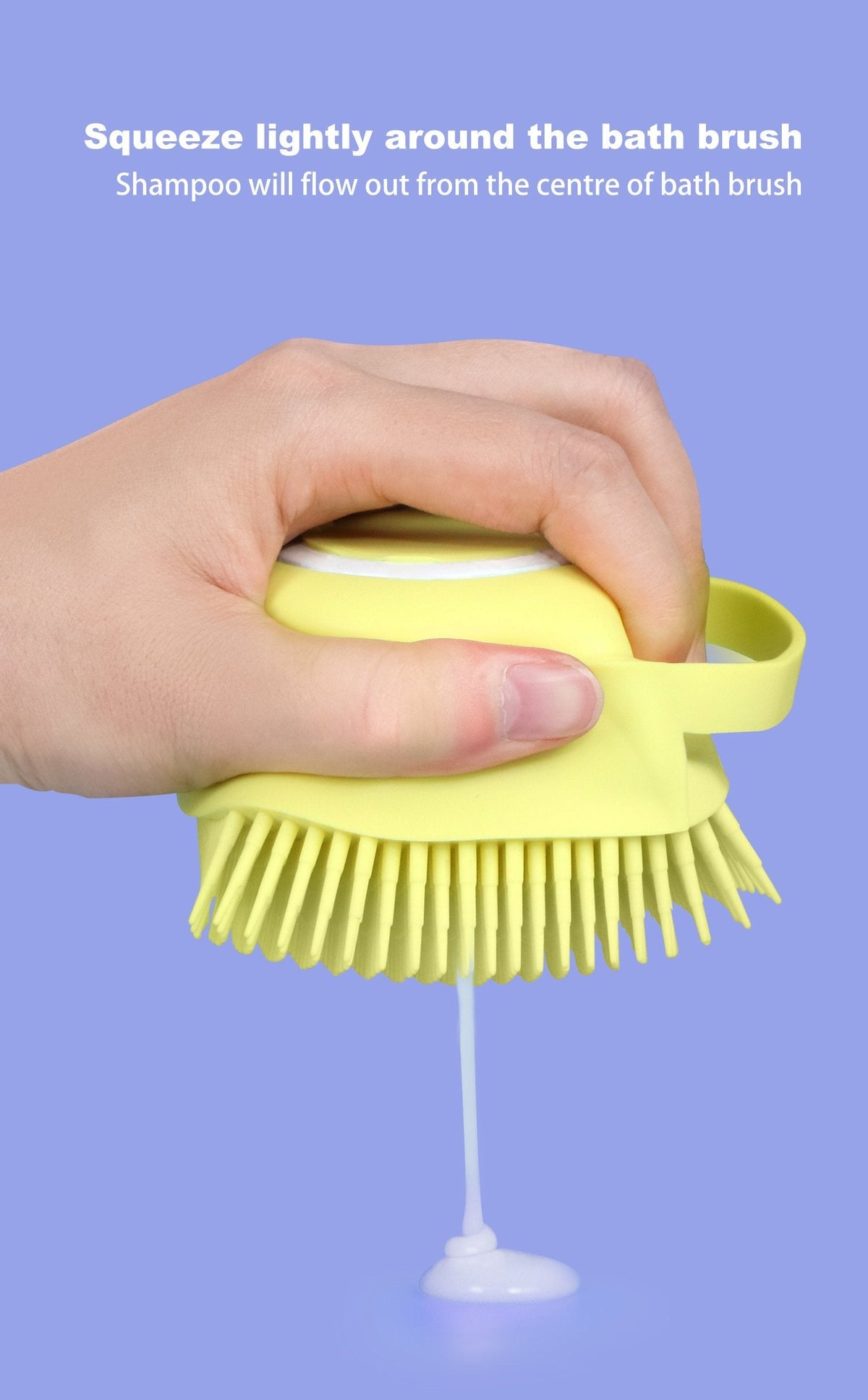 Hand squeezing a yellow silicone bath brush, dispensing shampoo from the center, on a purple background.