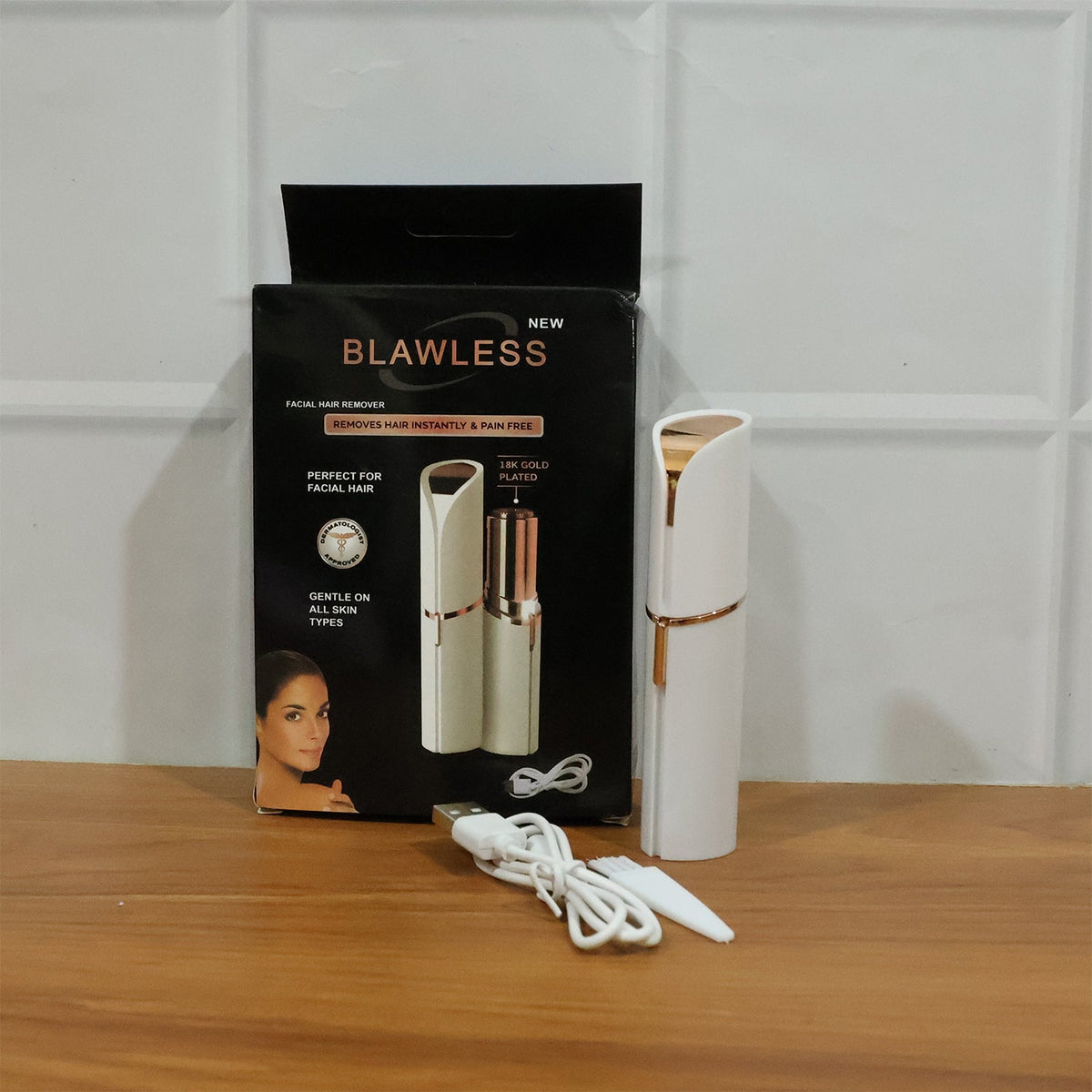 The facial hair remover, its charging cable, and cleaning brush displayed next to its open product box.