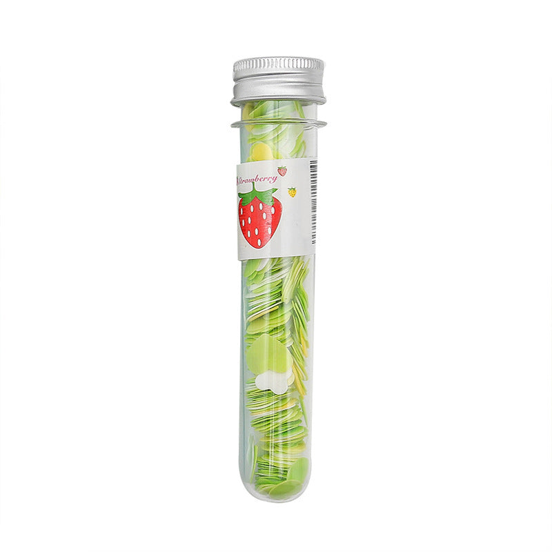 A clear tube with a silver cap and a strawberry label contains green and yellow flower-shaped paper soap strips.